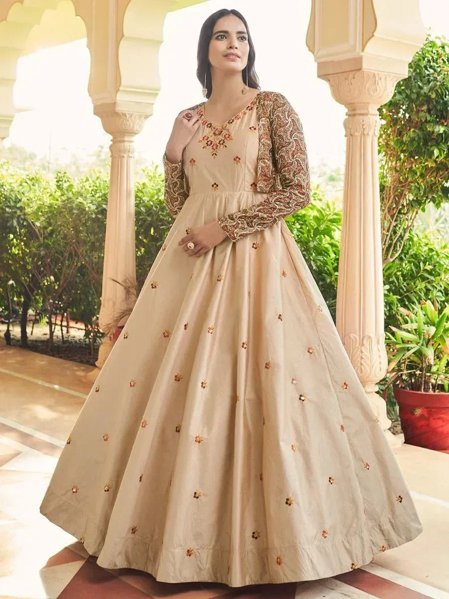 Beige embroidered ethnic gown with floral detailing, perfect for Indian weddings and festive occasions