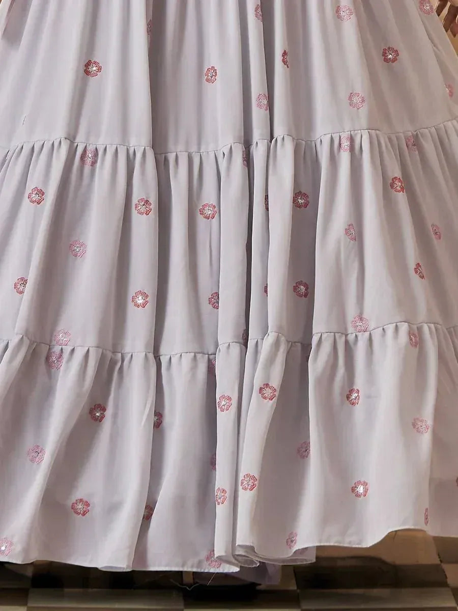 Light grey tiered ethnic gown with pink floral embroidery, perfect for festive occasions.