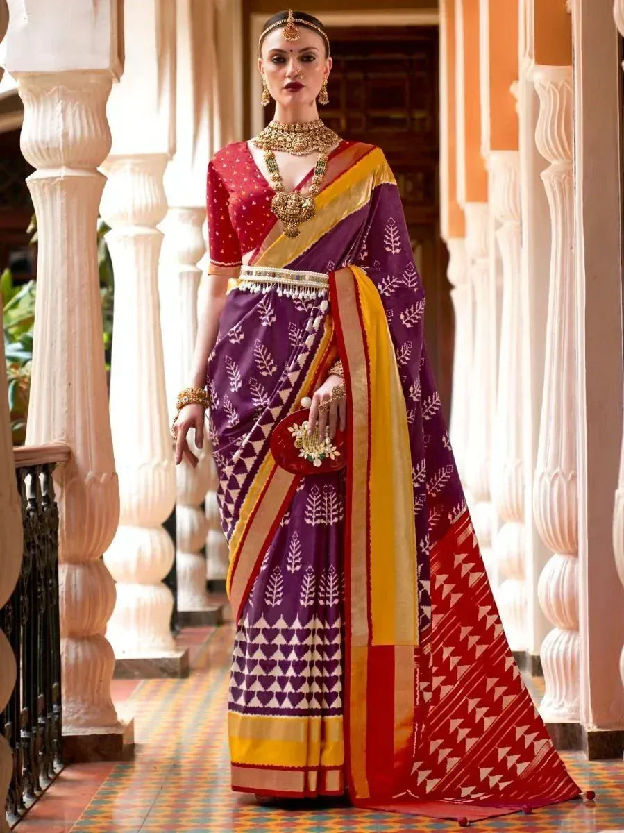 Woman in purple and red printed saree with gold jewelry, traditional Indian ethnic wear