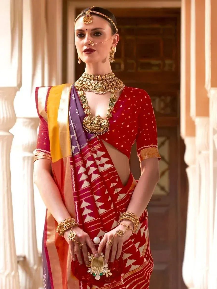 Woman in red and purple ethnic saree with gold jewelry, traditional Indian attire for festive occasions