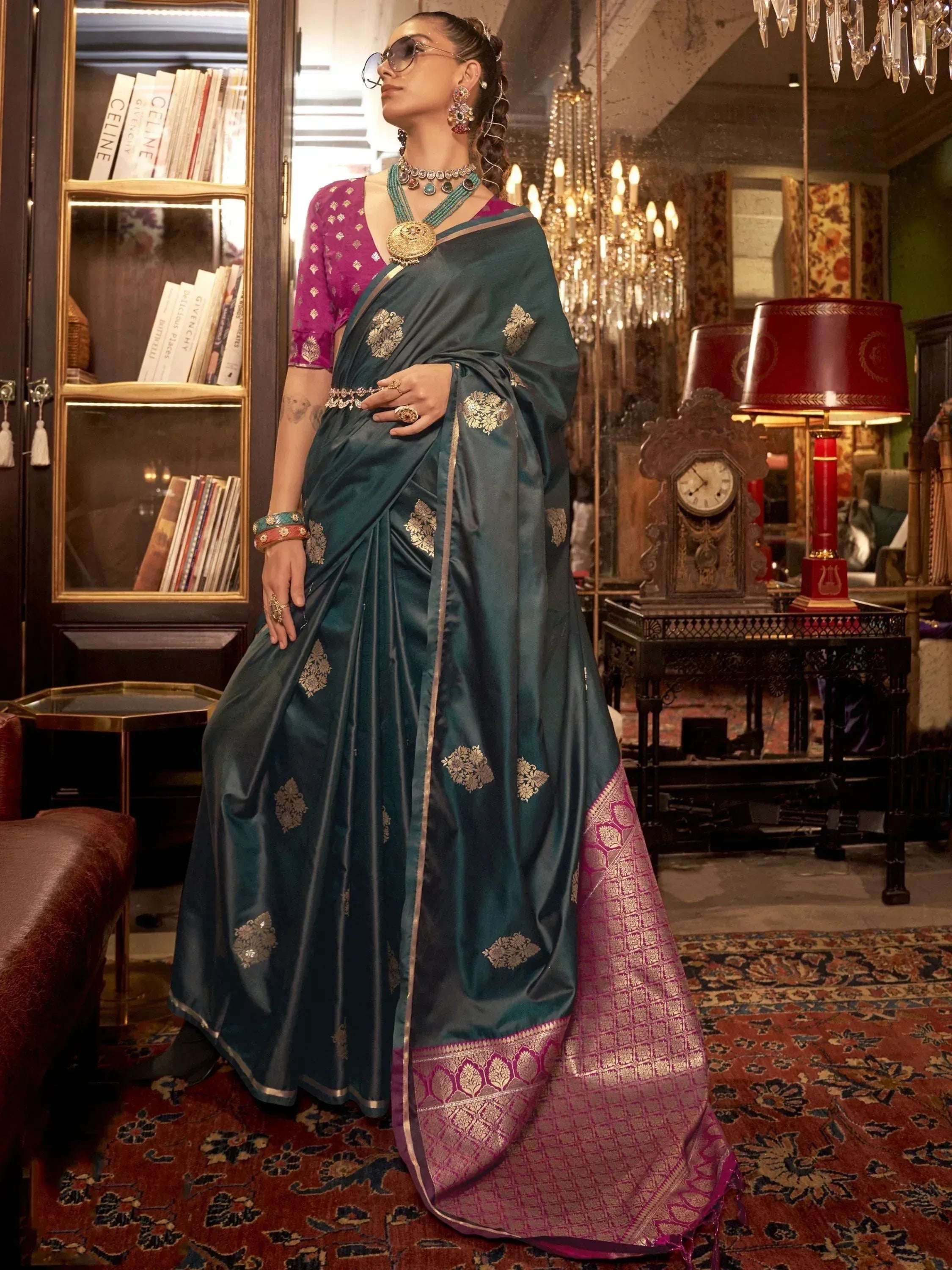 Teal silk saree with gold floral motifs and magenta border, paired with purple blouse, perfect for Indian ethnic wear occasions.