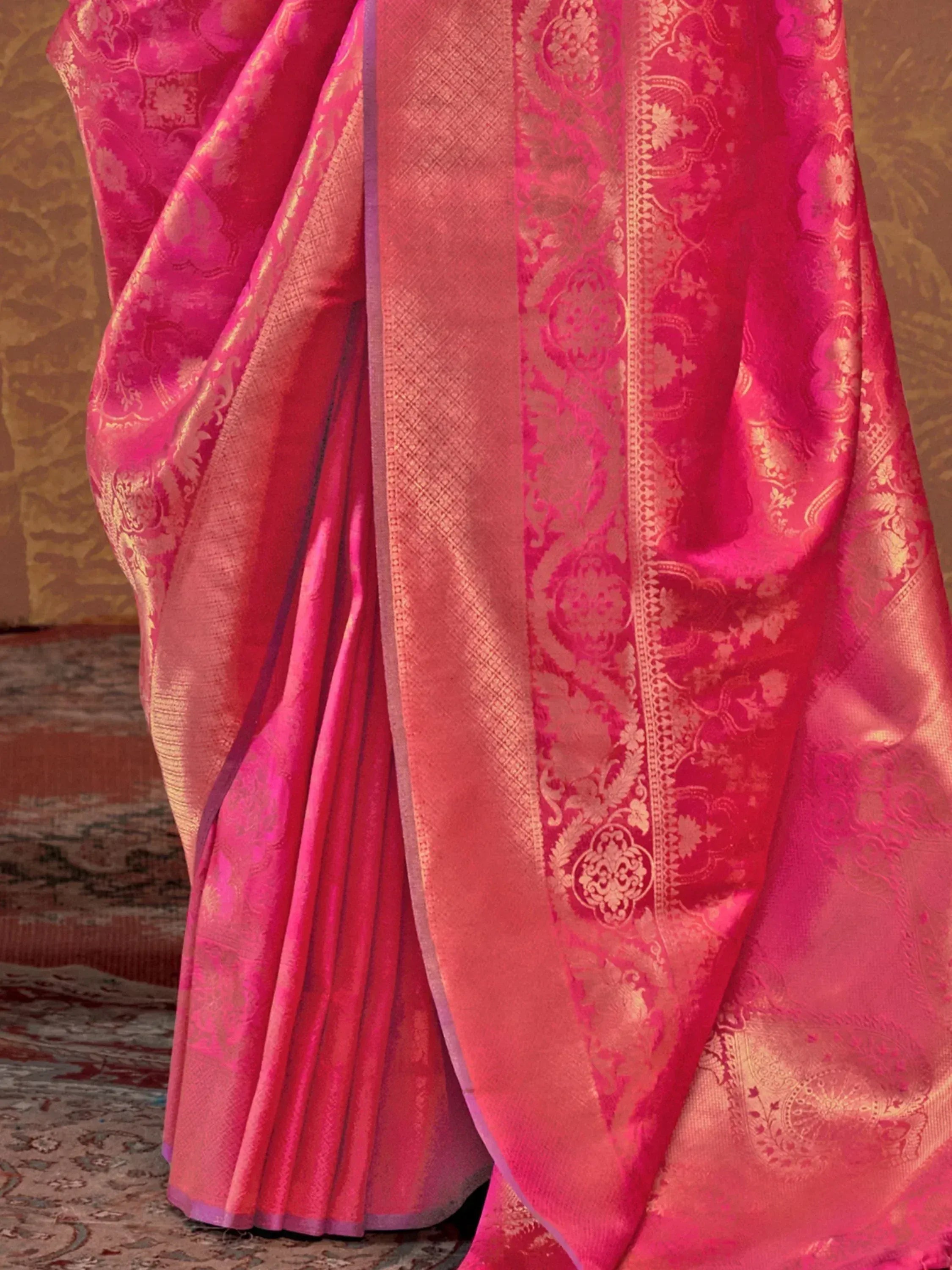 Pink designer saree with gold floral motifs and woven border, ideal for Indian ethnic wear