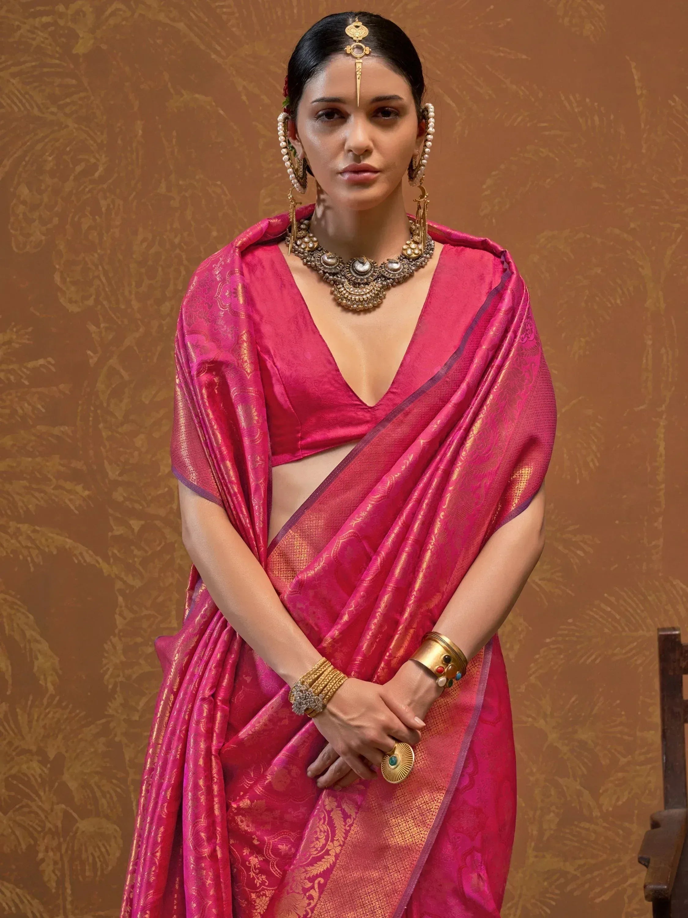 Pink silk saree with gold embroidery, traditional Indian ethnic wear, adorned with temple jewelry