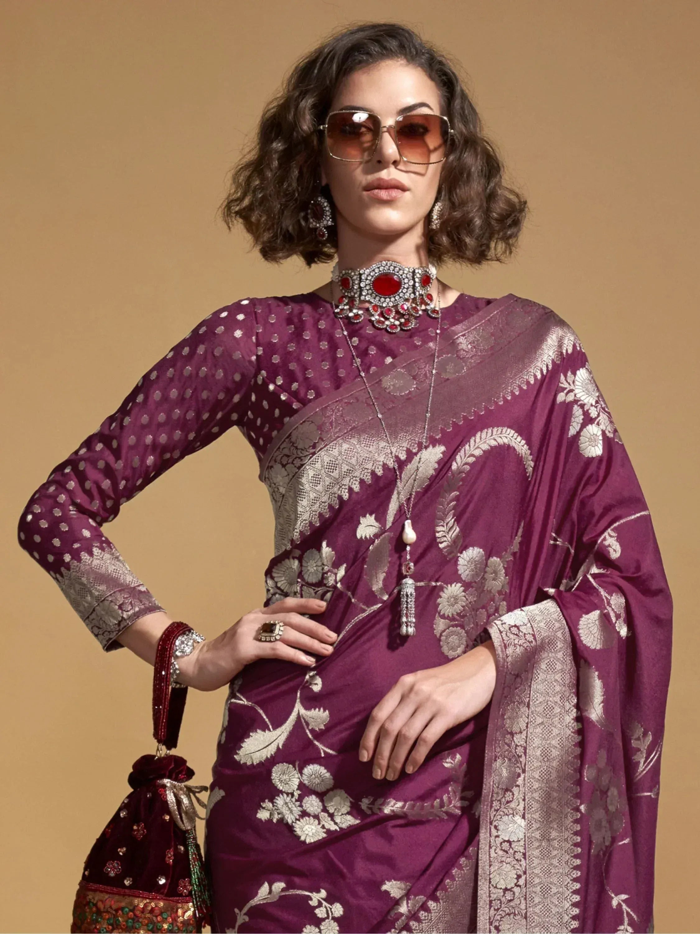 Purple floral embroidered saree with gold detailing, paired with statement jewelry and sunglasses