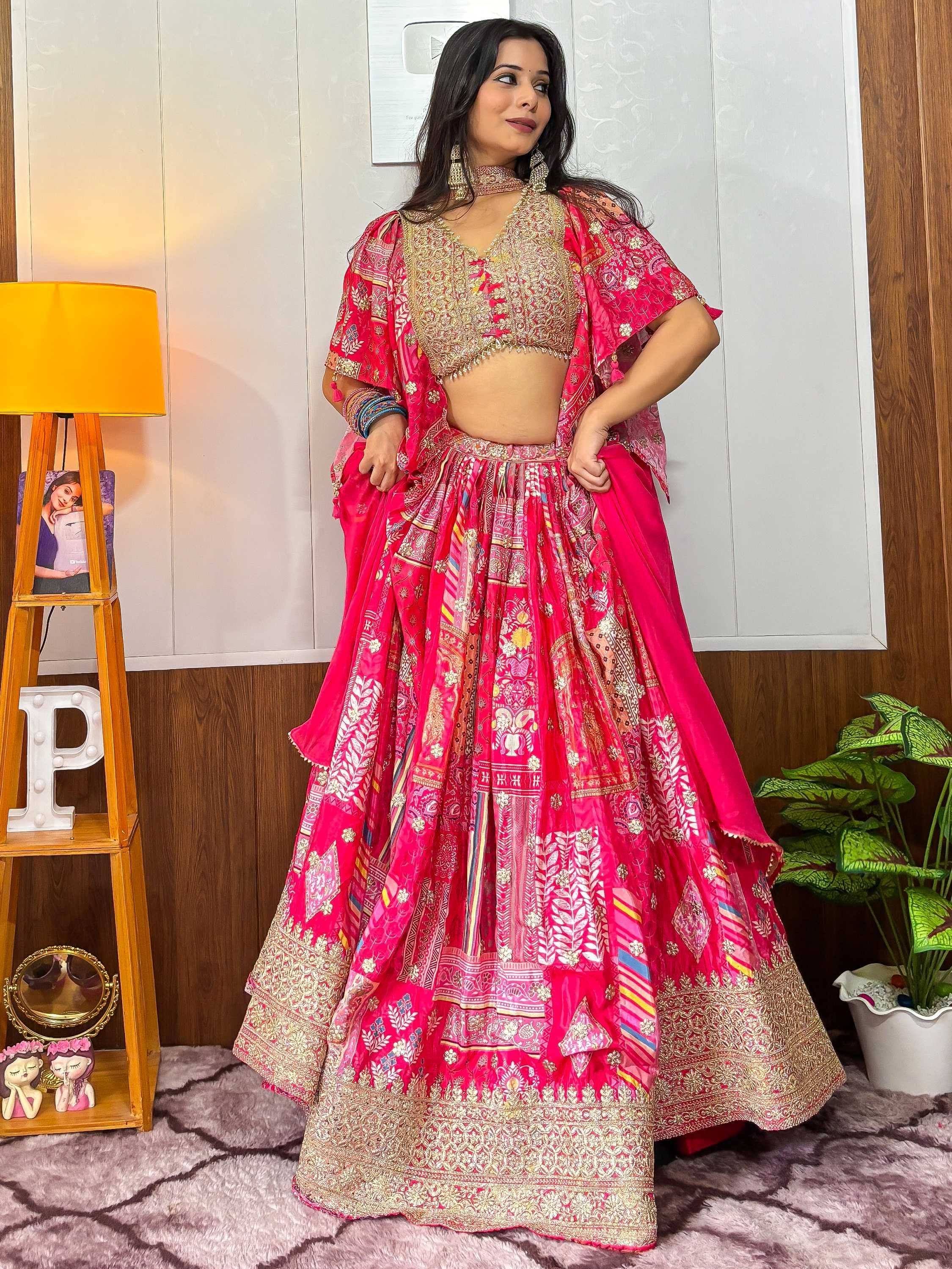 Vibrant pink lehenga choli with intricate gold embroidery and floral patterns, perfect for Indian ethnic wear.