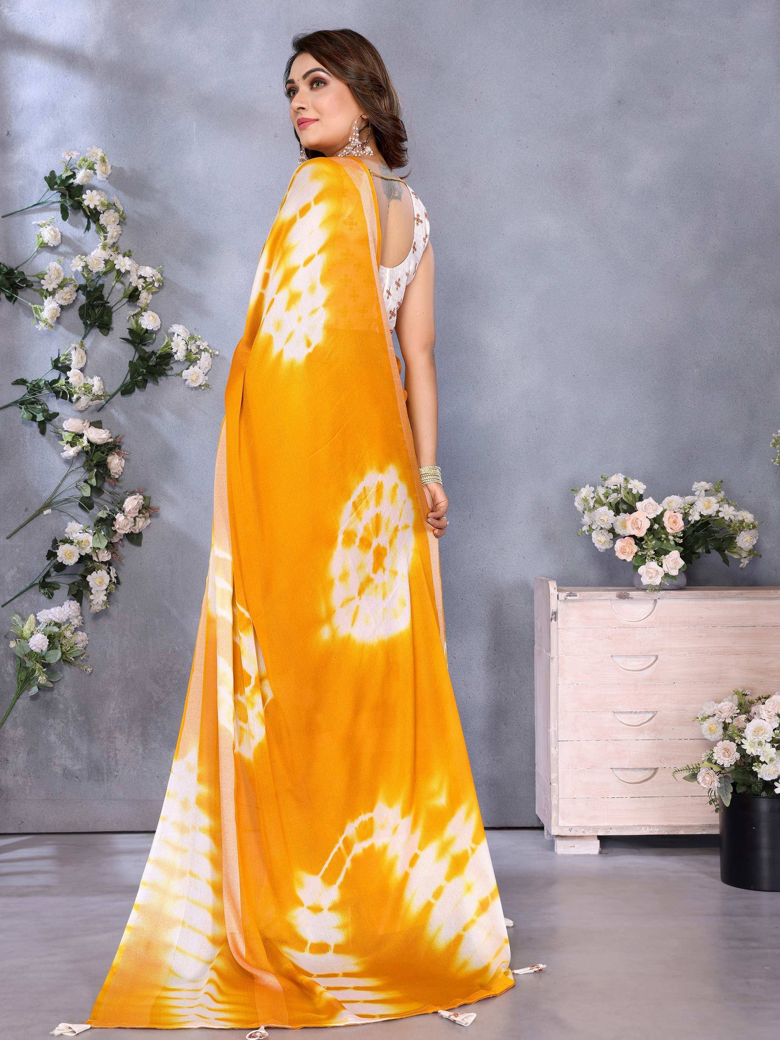 Vibrant yellow tie-dye saree with white patterns, styled with a sleeveless blouse, perfect for ethnic occasions.