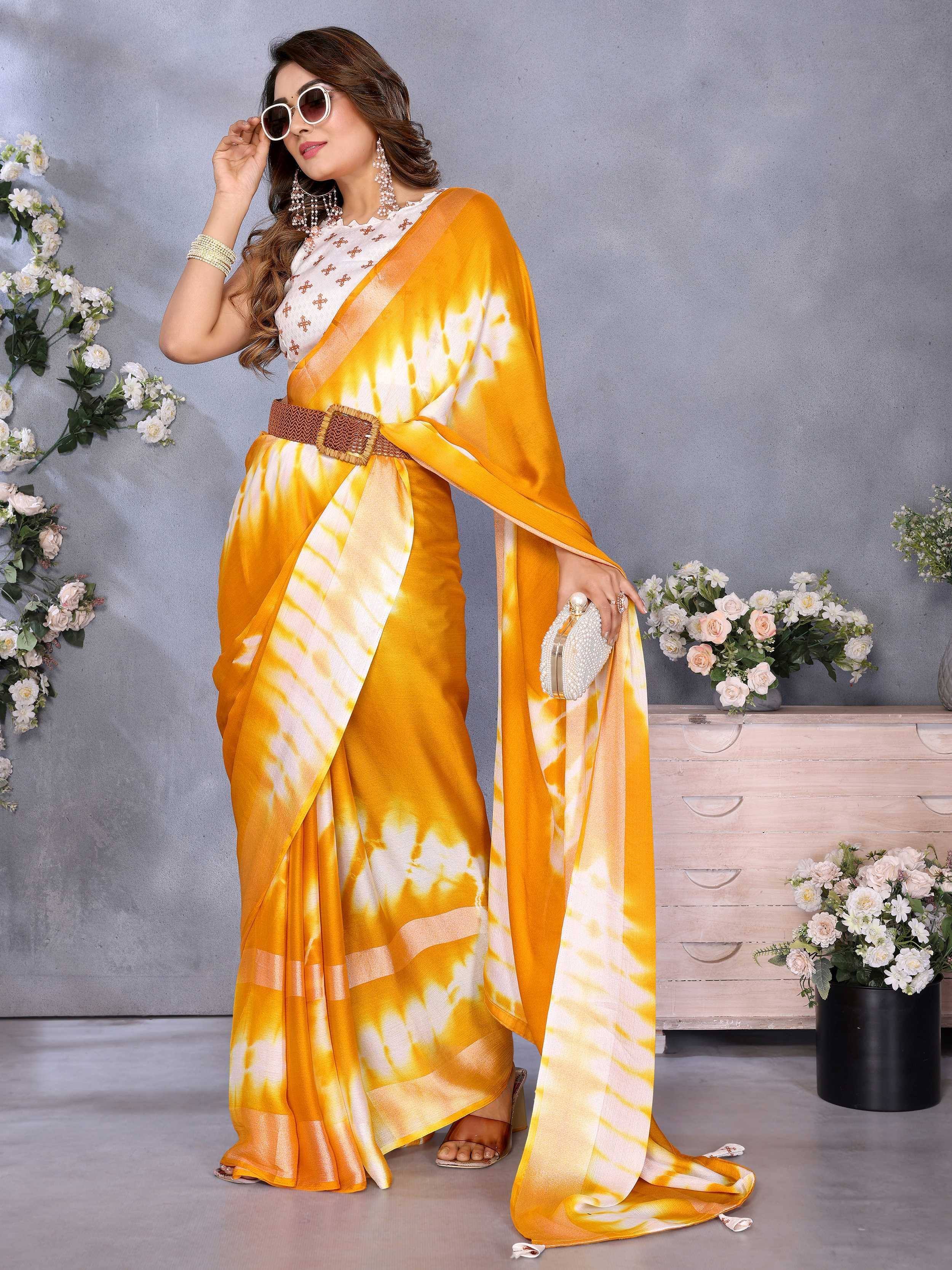 Yellow tie-dye saree with white blouse, accessorized with belt and clutch, perfect for ethnic occasions.