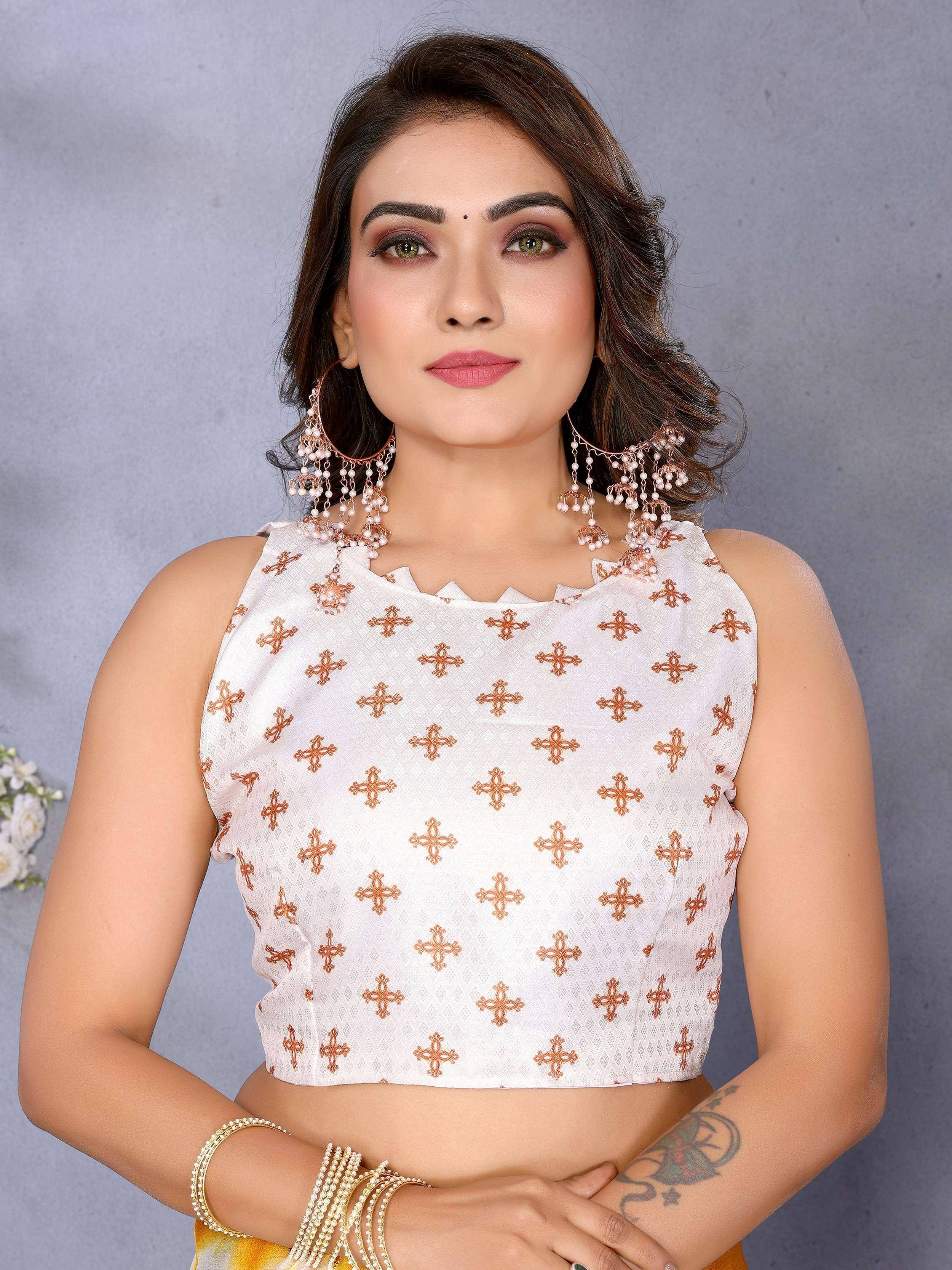 White embroidered crop top with orange motifs, paired with statement earrings and bangles