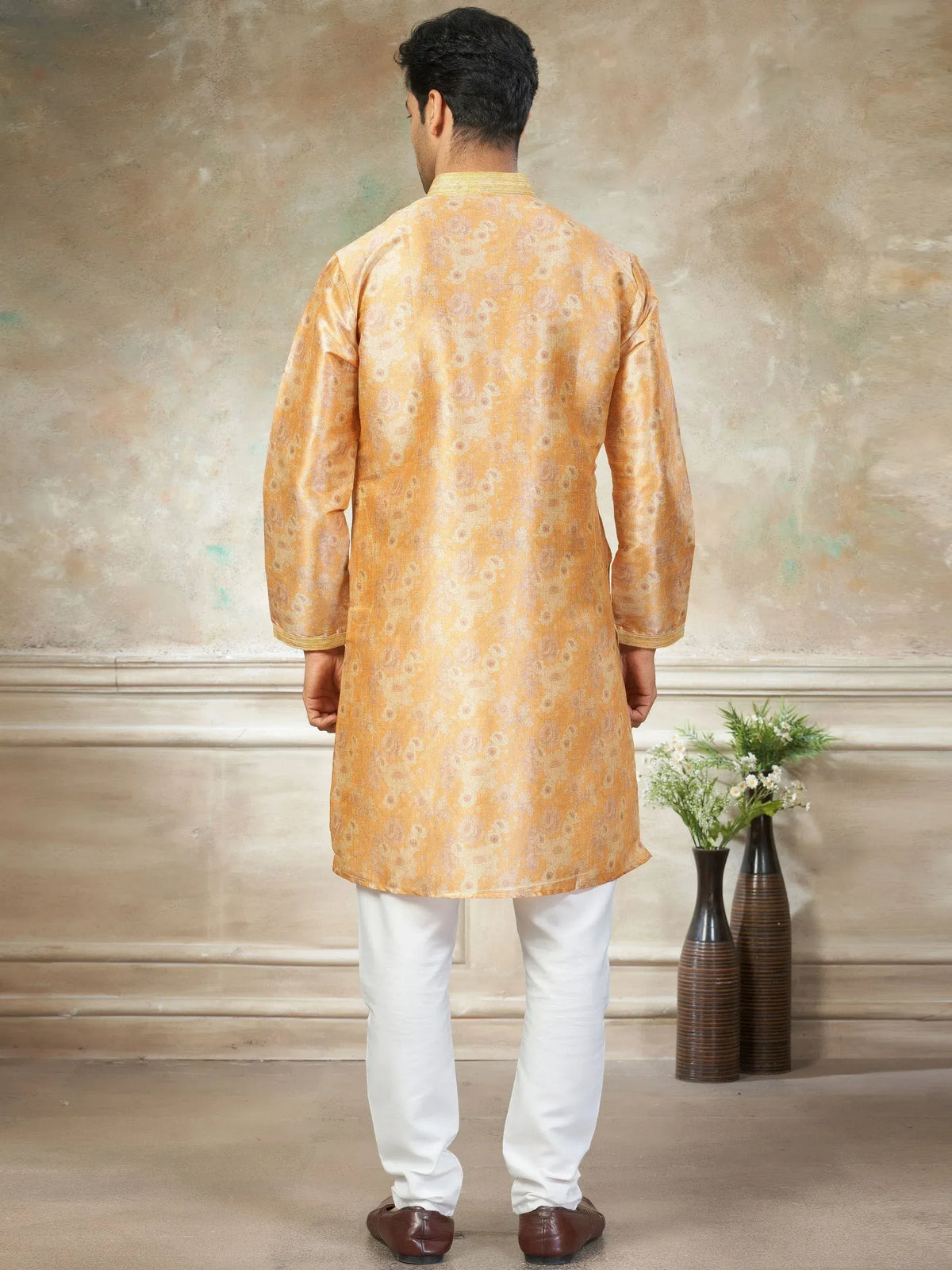 Men's golden floral kurta with white pants, traditional Indian ethnic wear for festive occasions
