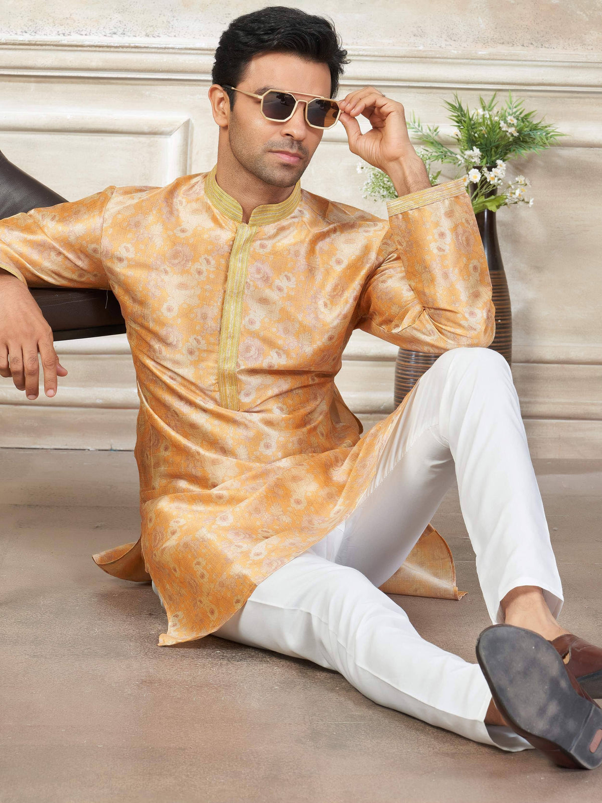 Man in golden floral kurta with white pants, stylish ethnic wear for men