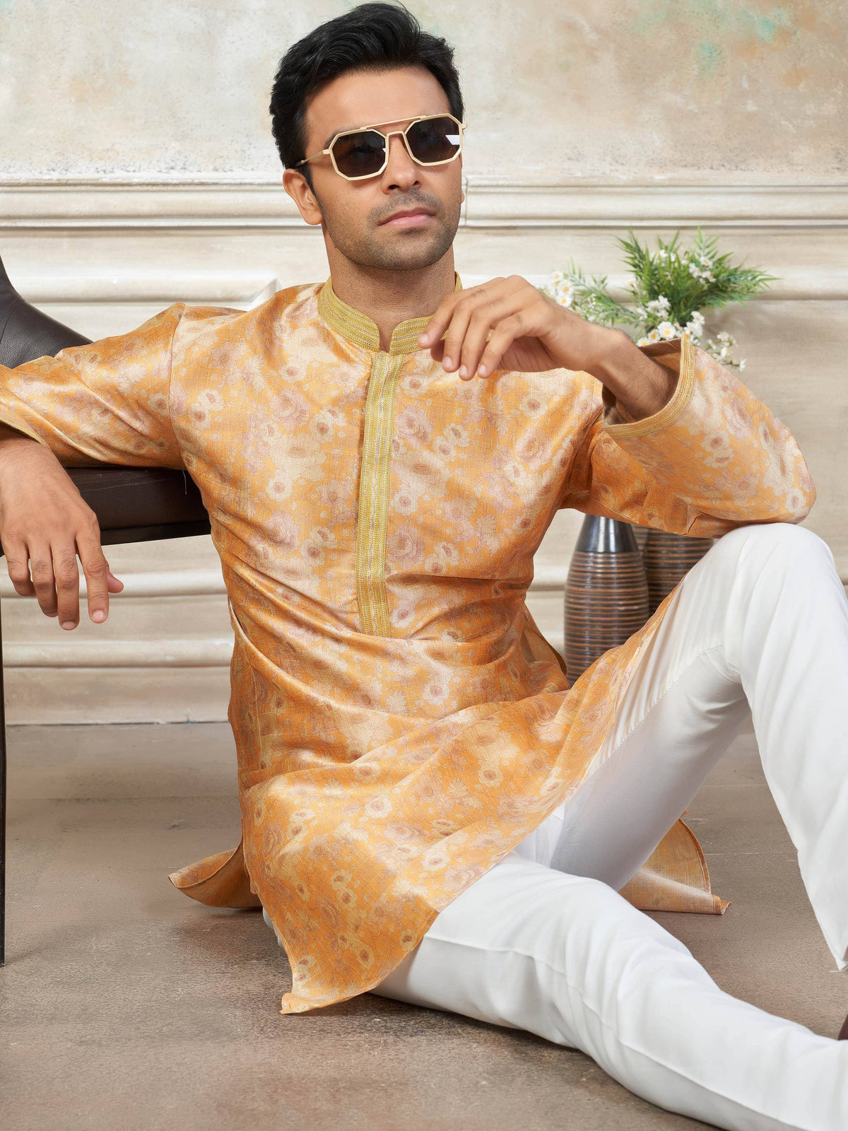 Man in golden floral kurta with white pants, stylish ethnic wear for men
