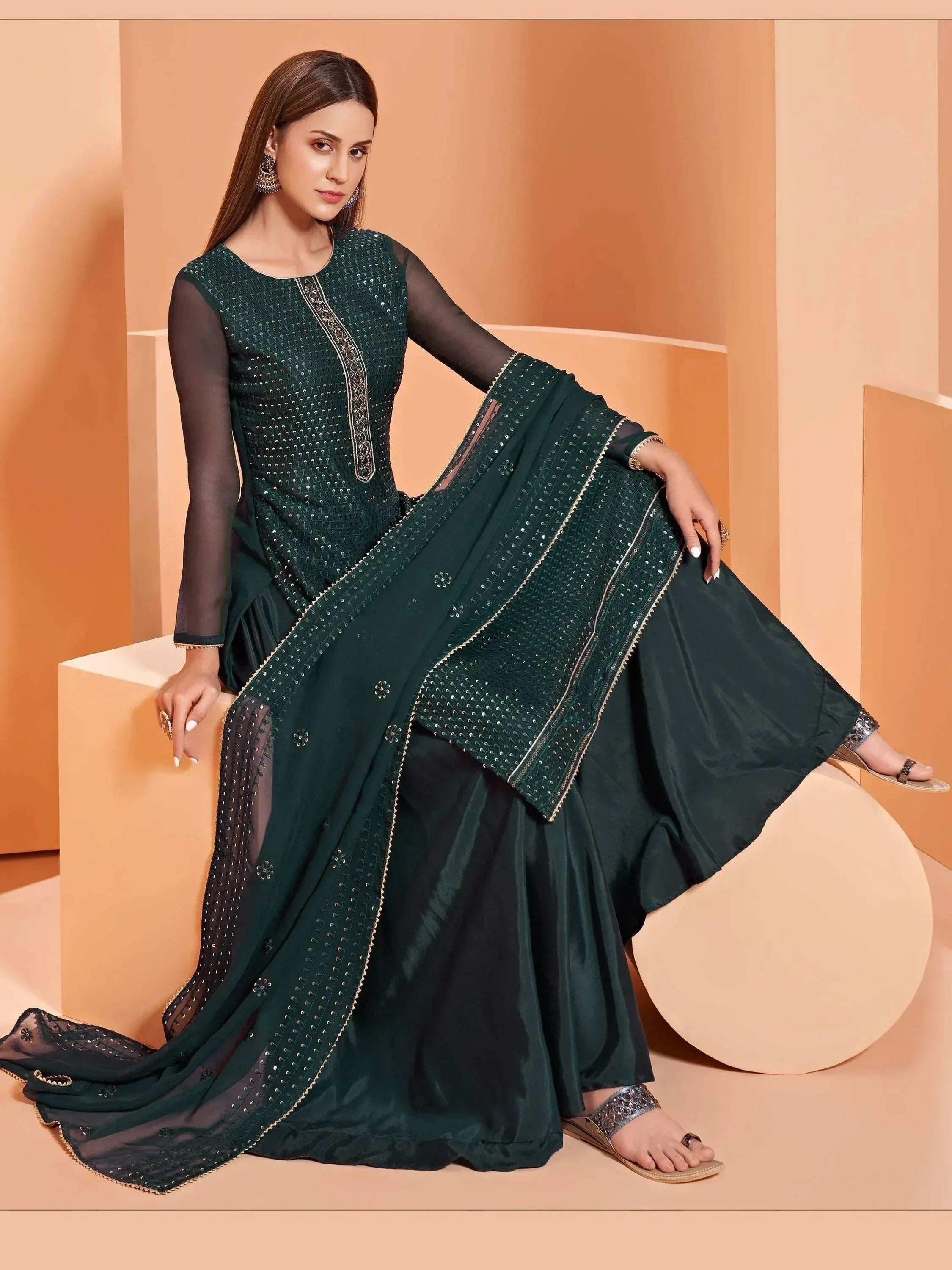 Elegant dark green ethnic gown with sequin embroidery and sheer sleeves, perfect for festive occasions.