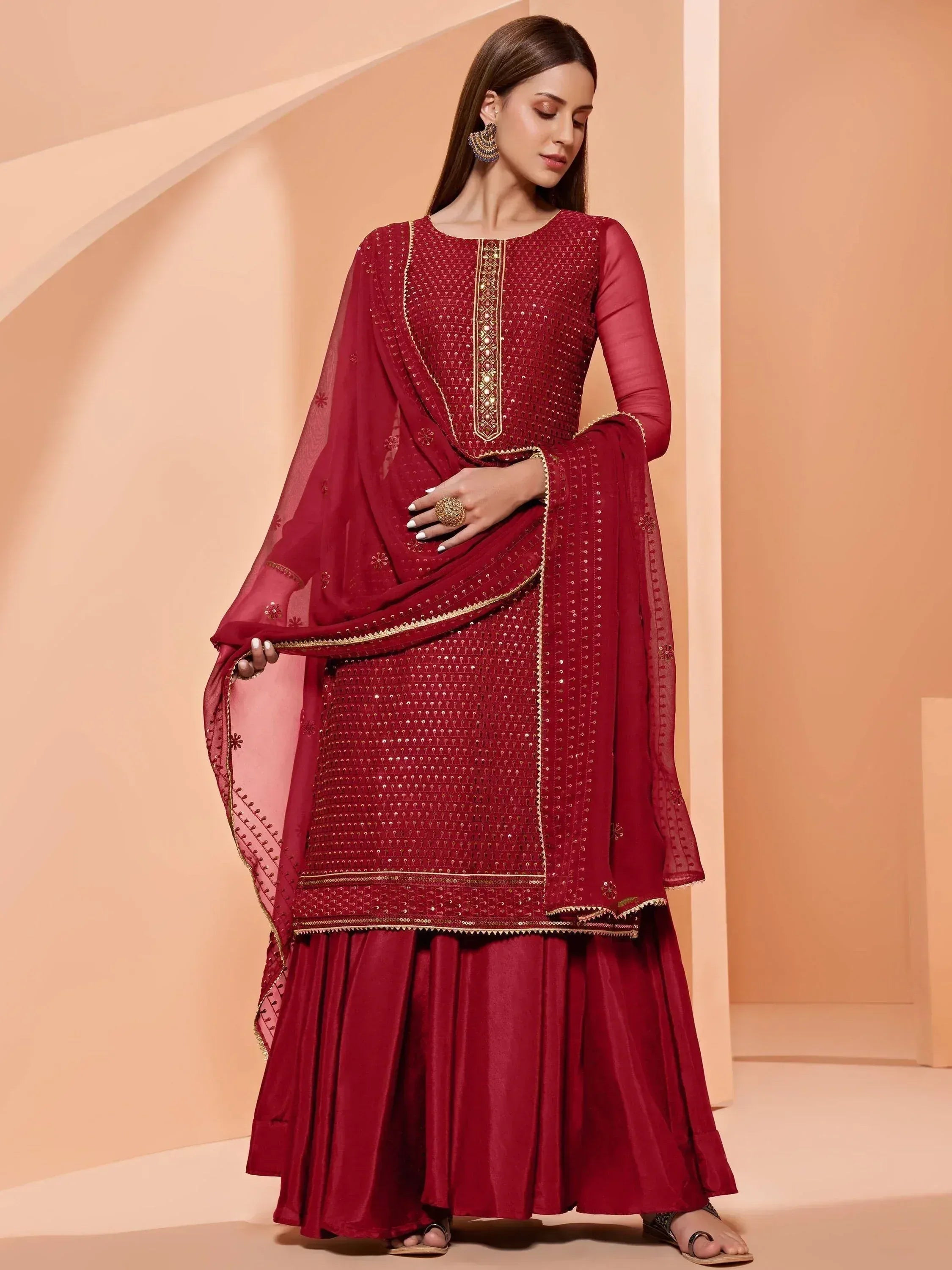 Elegant maroon ethnic salwar kameez with gold embroidery and sequin detailing, perfect for festive occasions.