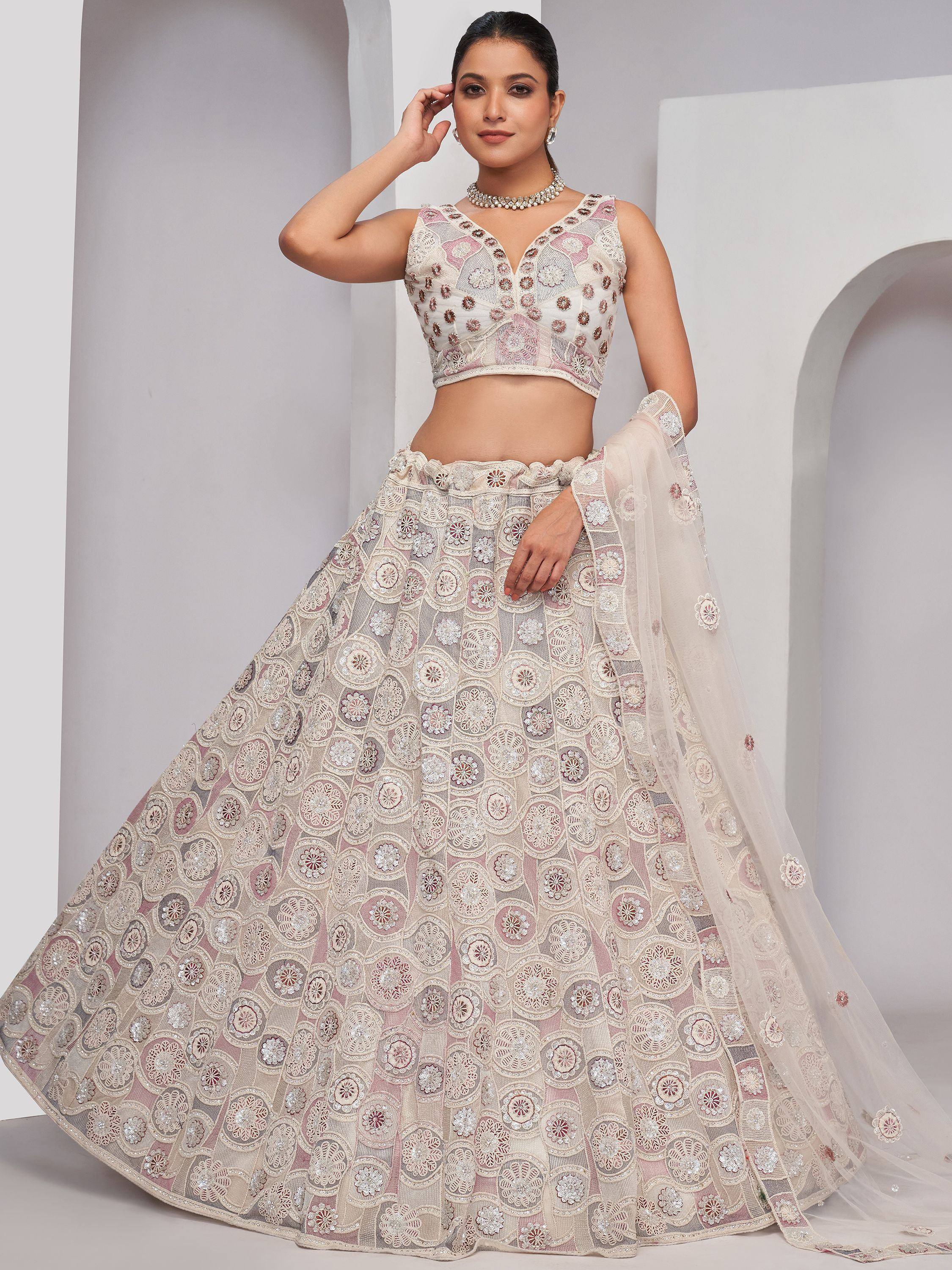 Elegant ivory and pink embroidered lehenga choli with floral motifs, perfect for Indian weddings and festive occasions.