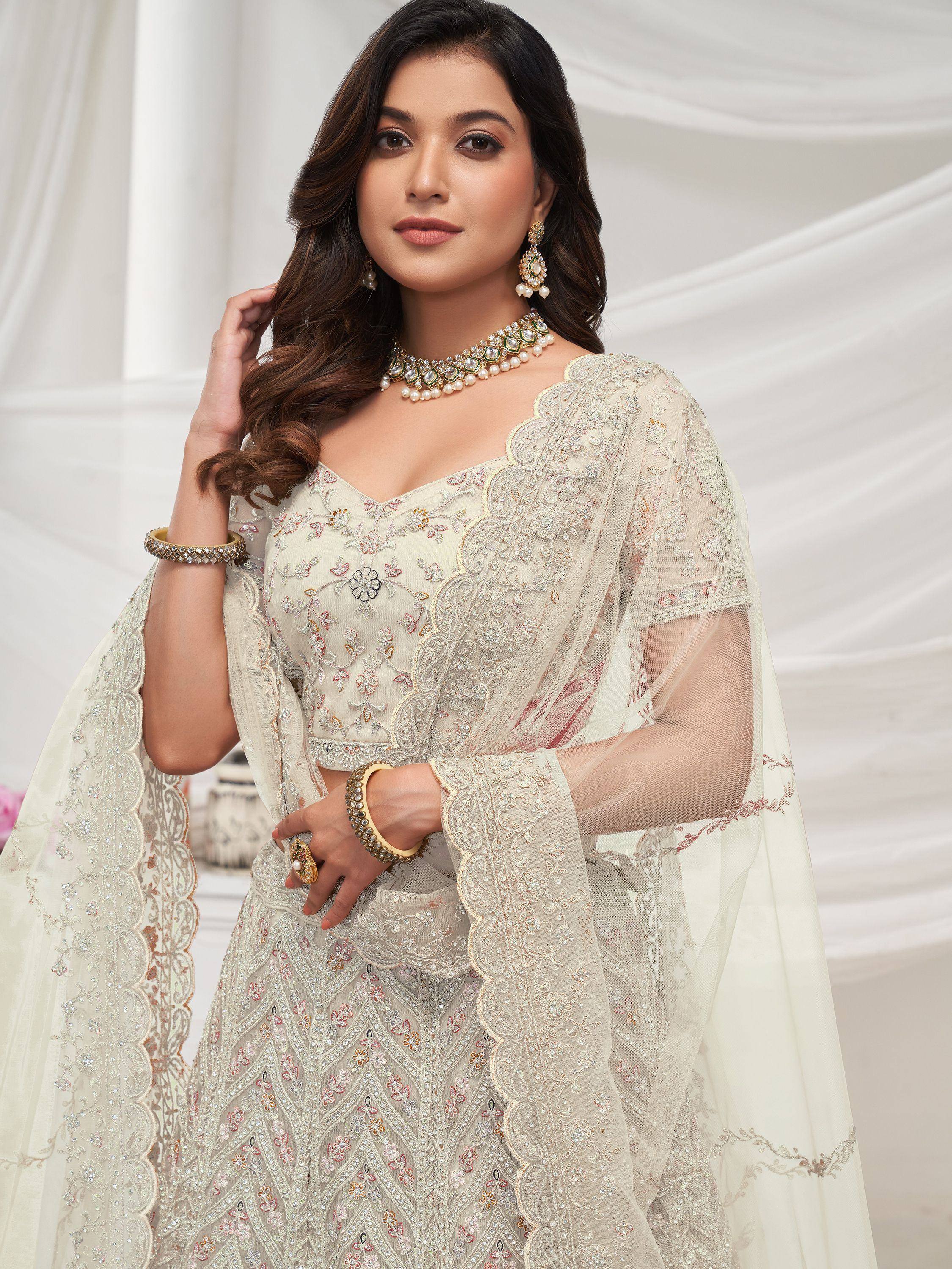 Elegant ivory embroidered lehenga choli with sheer cape, perfect for Indian weddings and festive occasions.