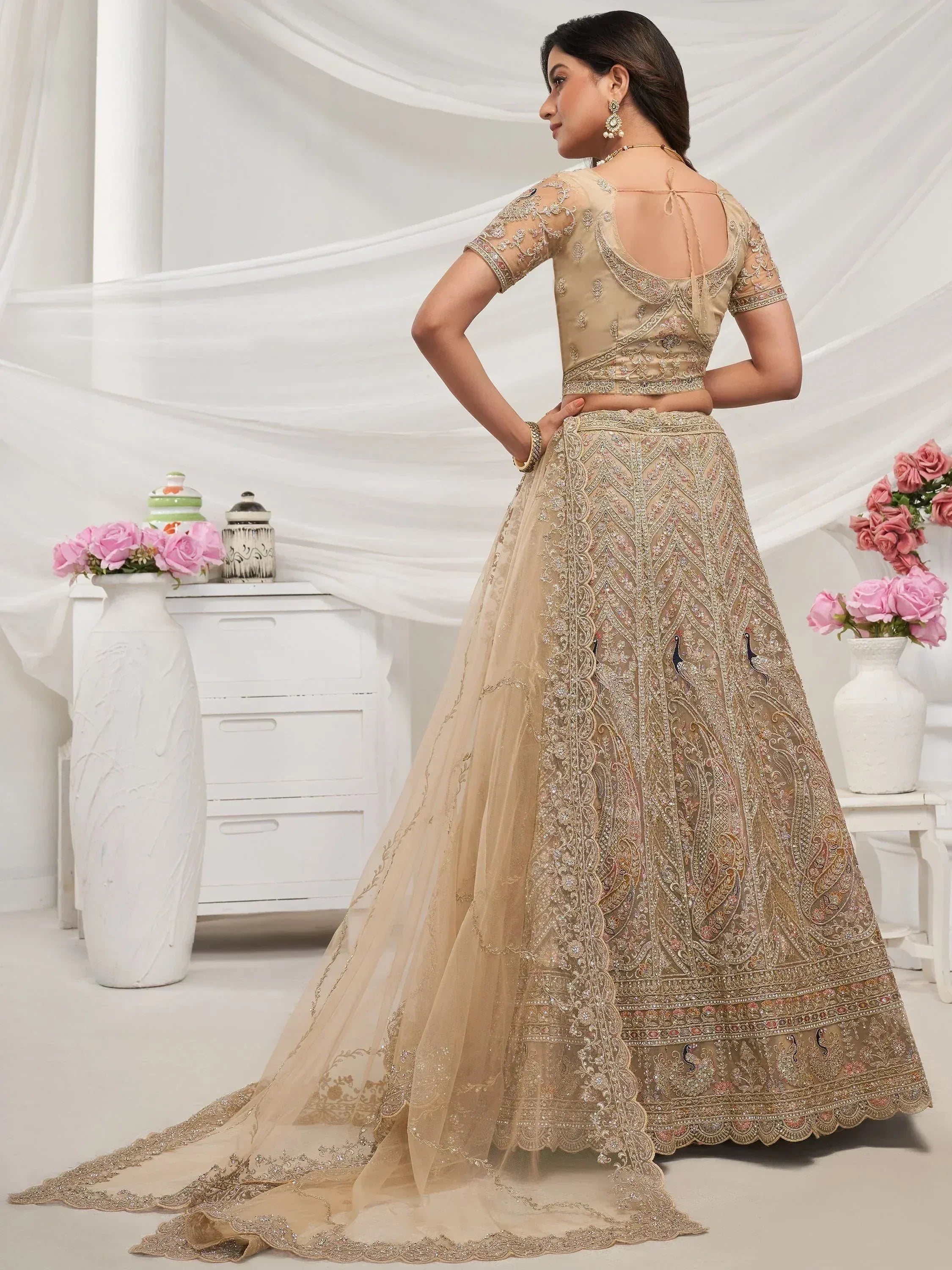 Beige embroidered lehenga choli with peacock motifs, sheer dupatta, and back tie blouse for Indian weddings