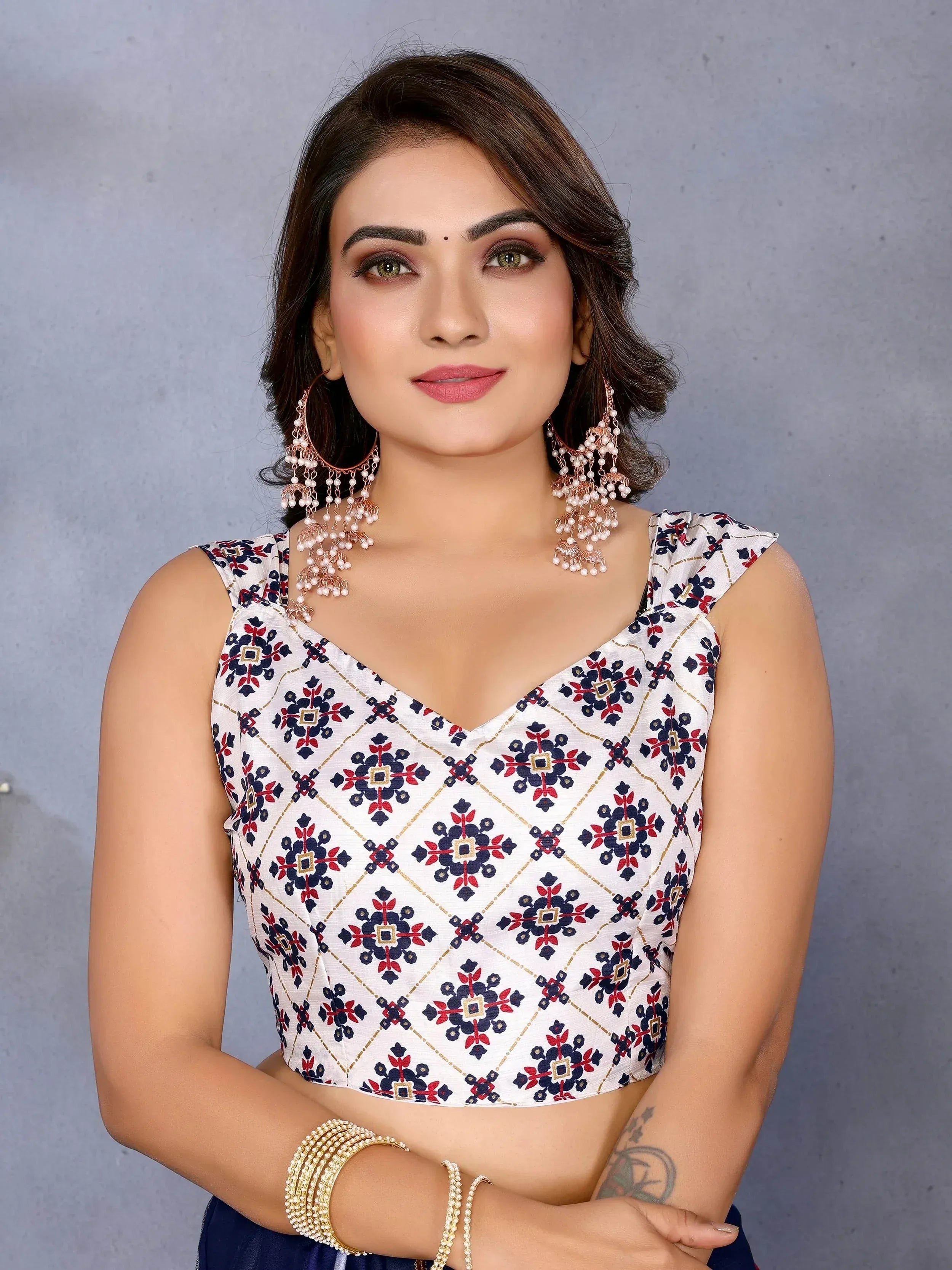 Woman in floral print ethnic crop top with pearl earrings and bangles, perfect for Indian festive wear