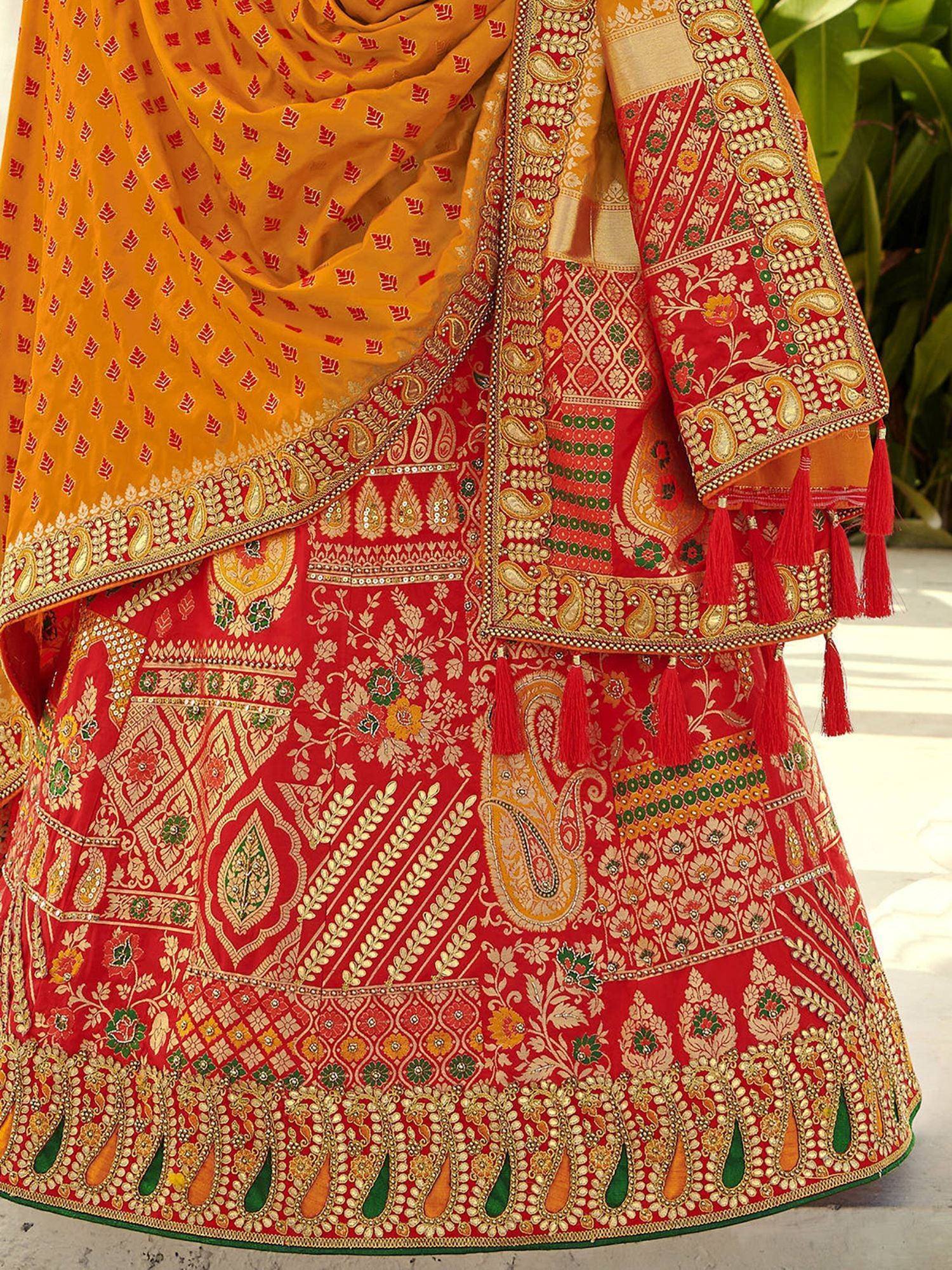 Red and gold embroidered lehenga choli with yellow dupatta, featuring intricate paisley and floral designs for Indian ethnic wear.
