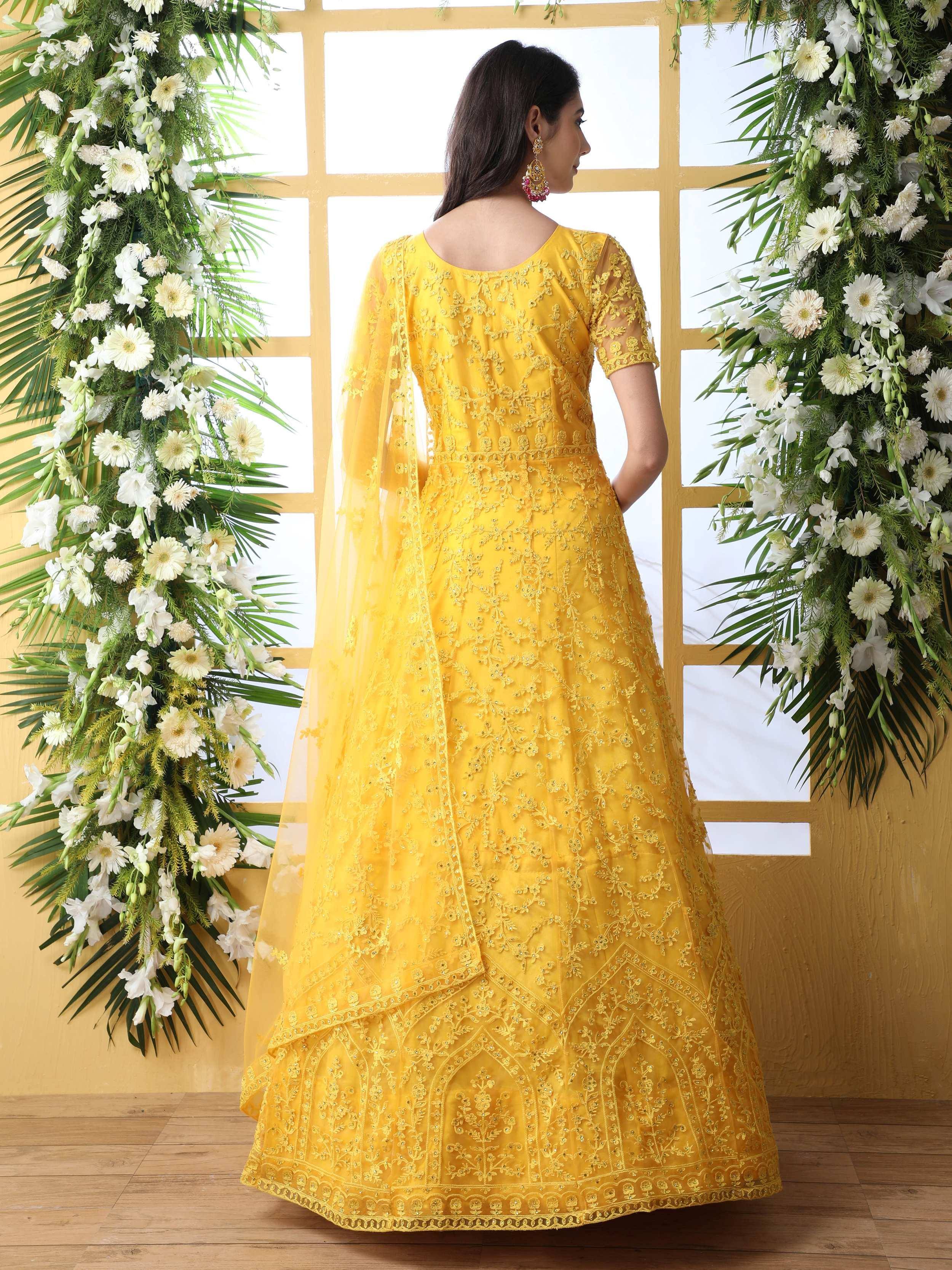 Yellow embroidered anarkali suit with sheer dupatta, floral backdrop, ethnic wear for women
