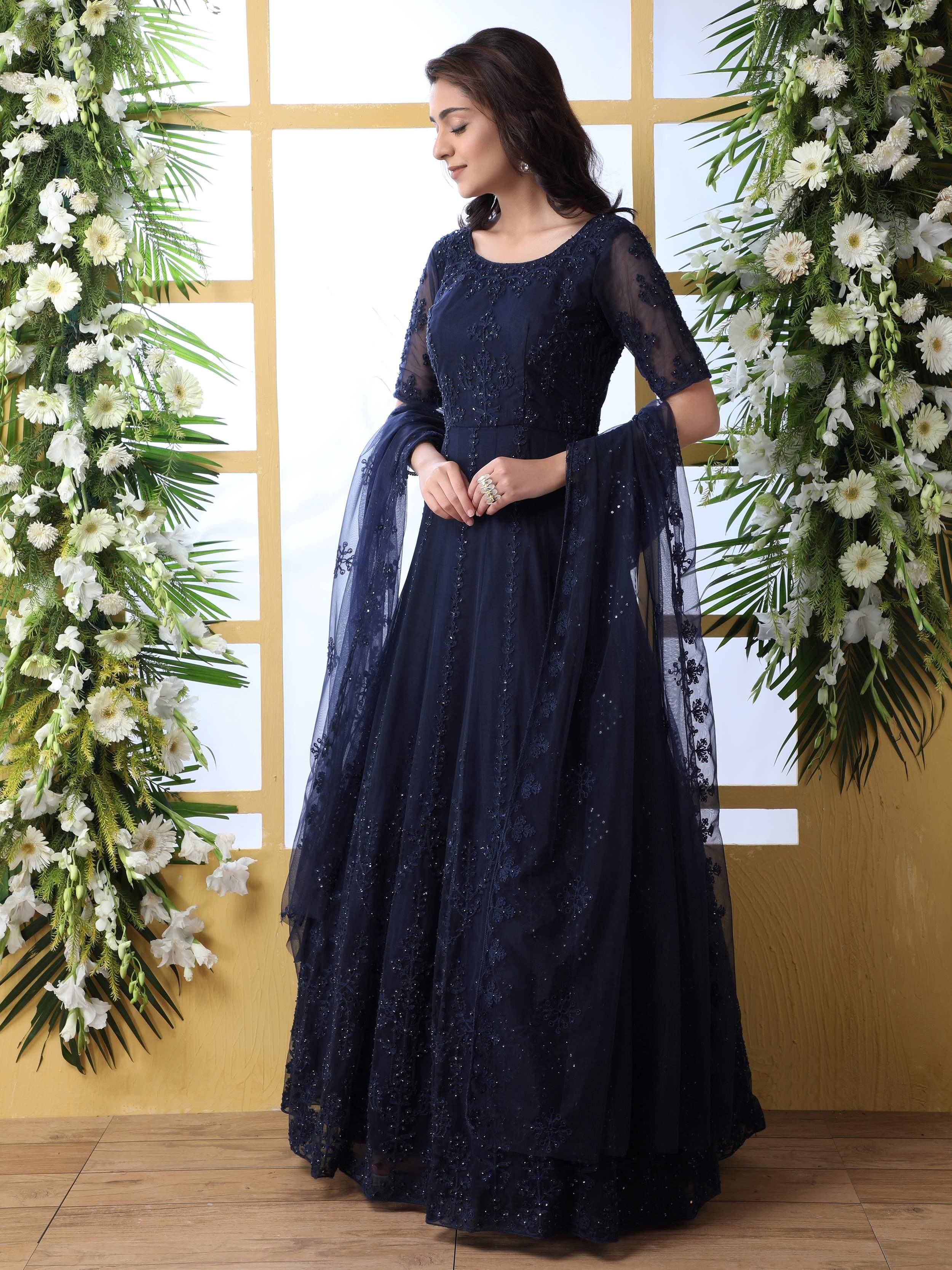 Navy blue embroidered ethnic gown with sheer sleeves and floral backdrop