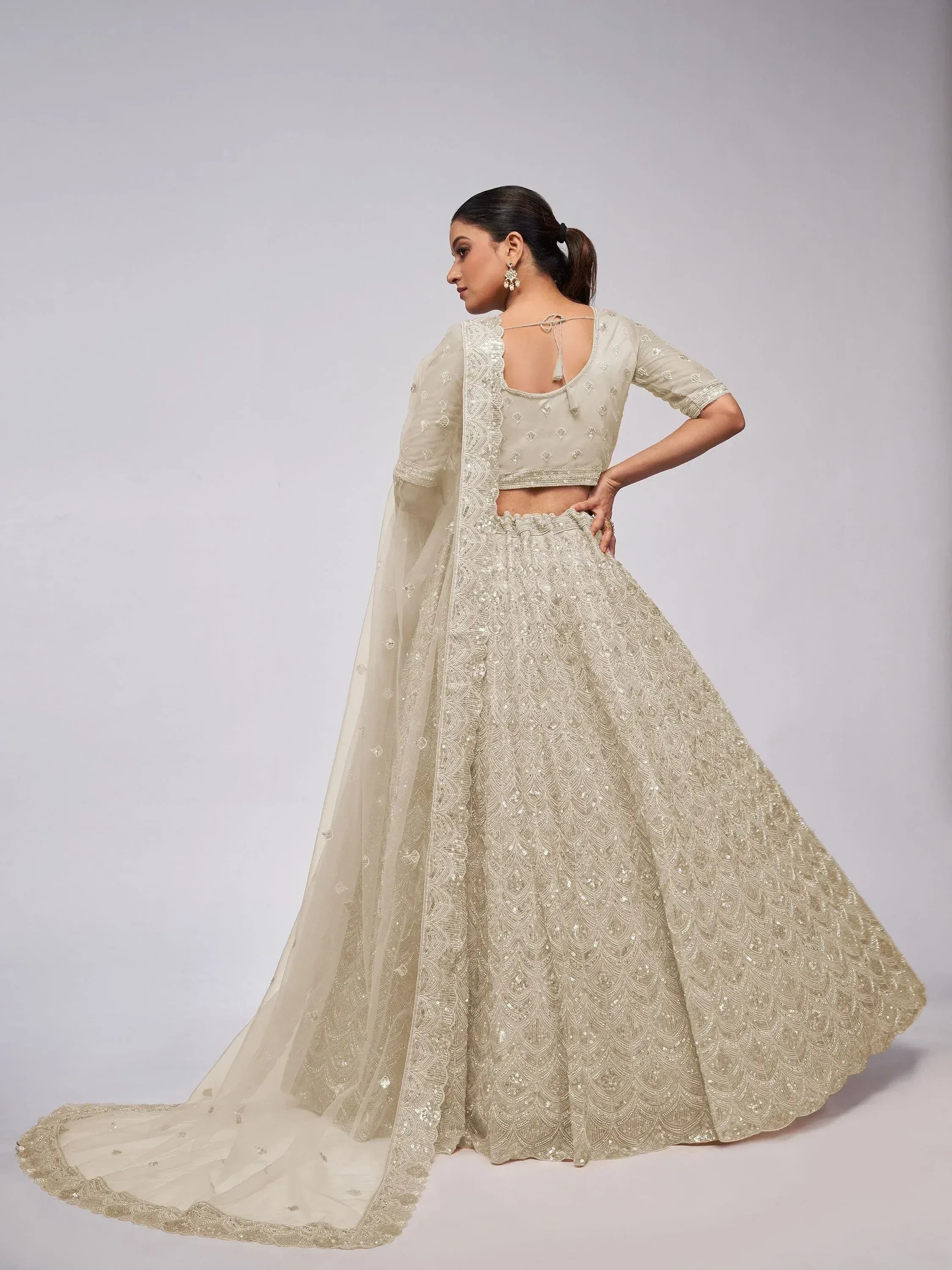 Elegant cream lehenga choli with intricate embroidery and flowing dupatta for Indian ethnic wear