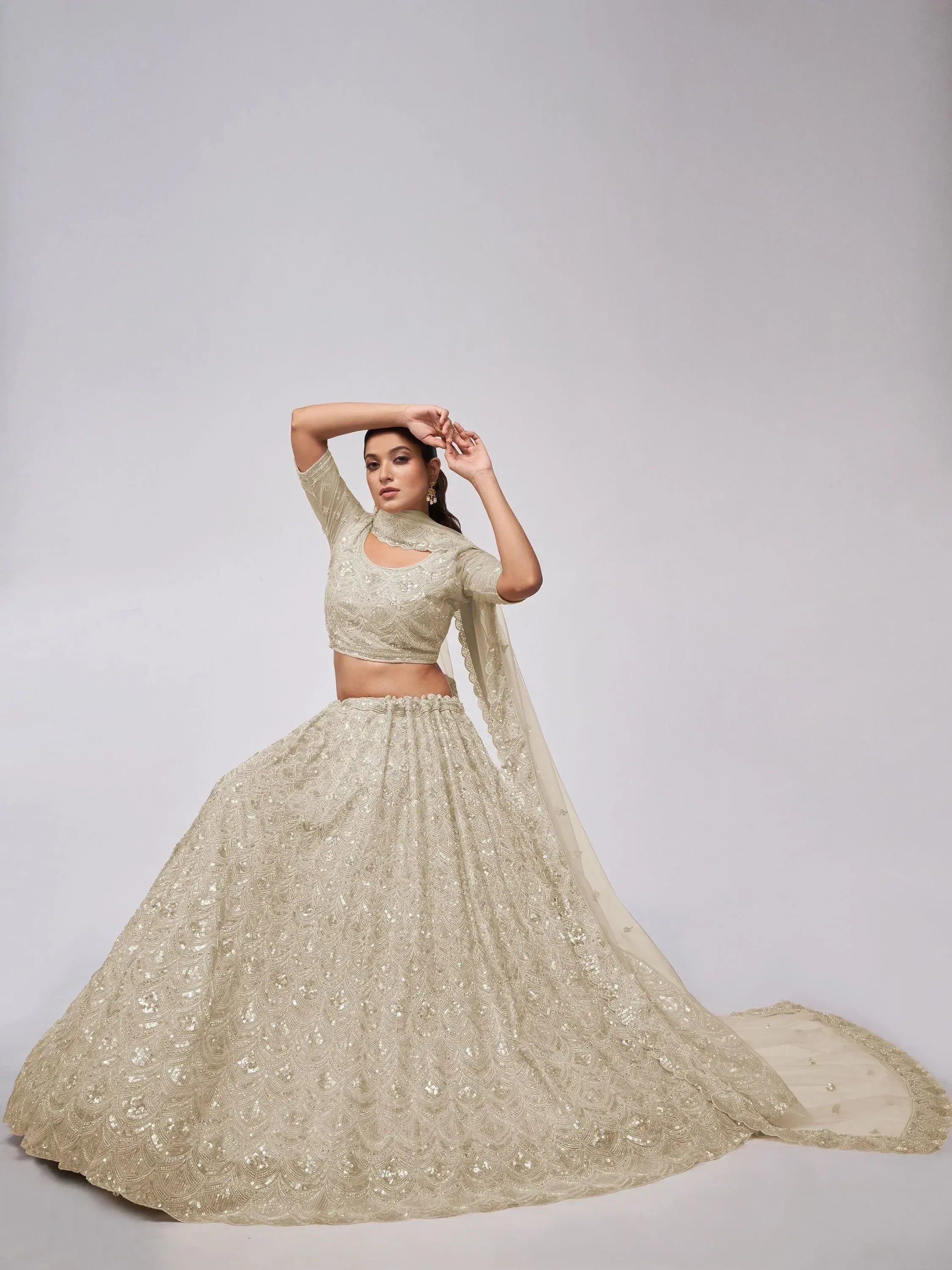 Elegant cream lehenga choli with intricate embroidery and sequin detailing for festive occasions