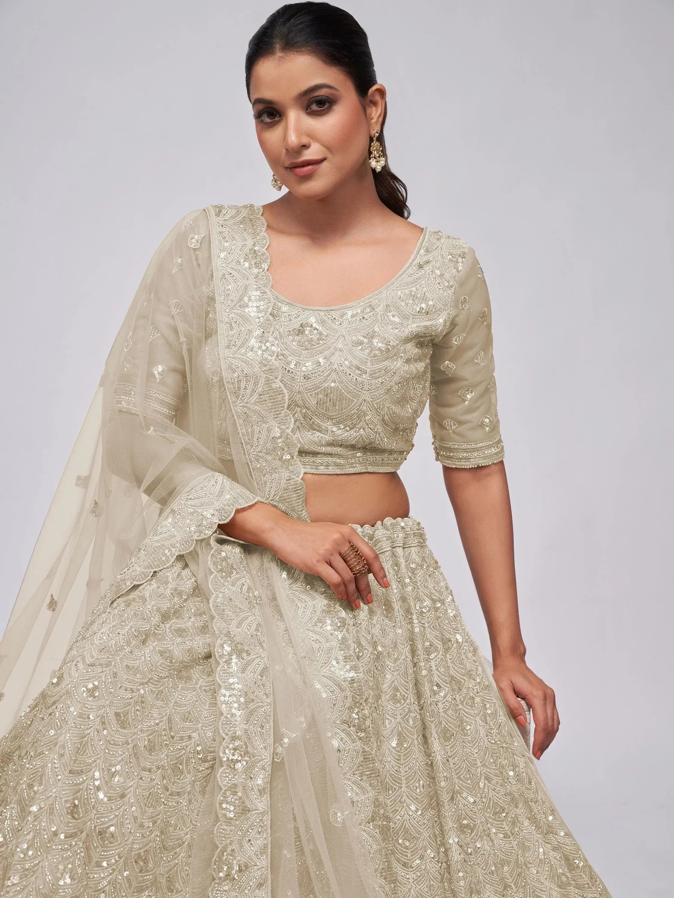 Elegant cream lehenga choli with intricate sequin embroidery and sheer dupatta for Indian ethnic wear