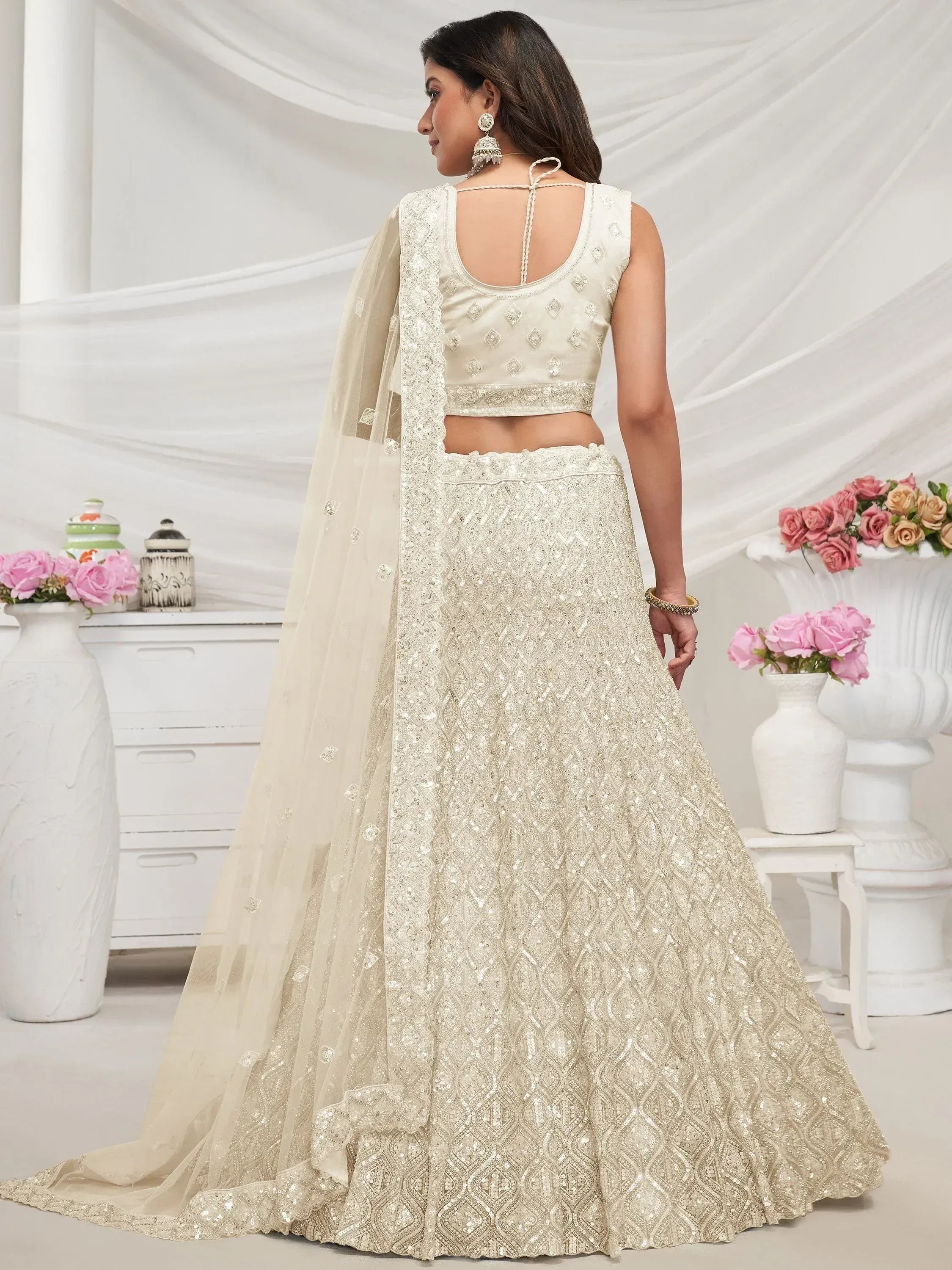 Ivory designer lehenga choli with sequin embroidery and sheer dupatta, perfect for Indian weddings and festive occasions.