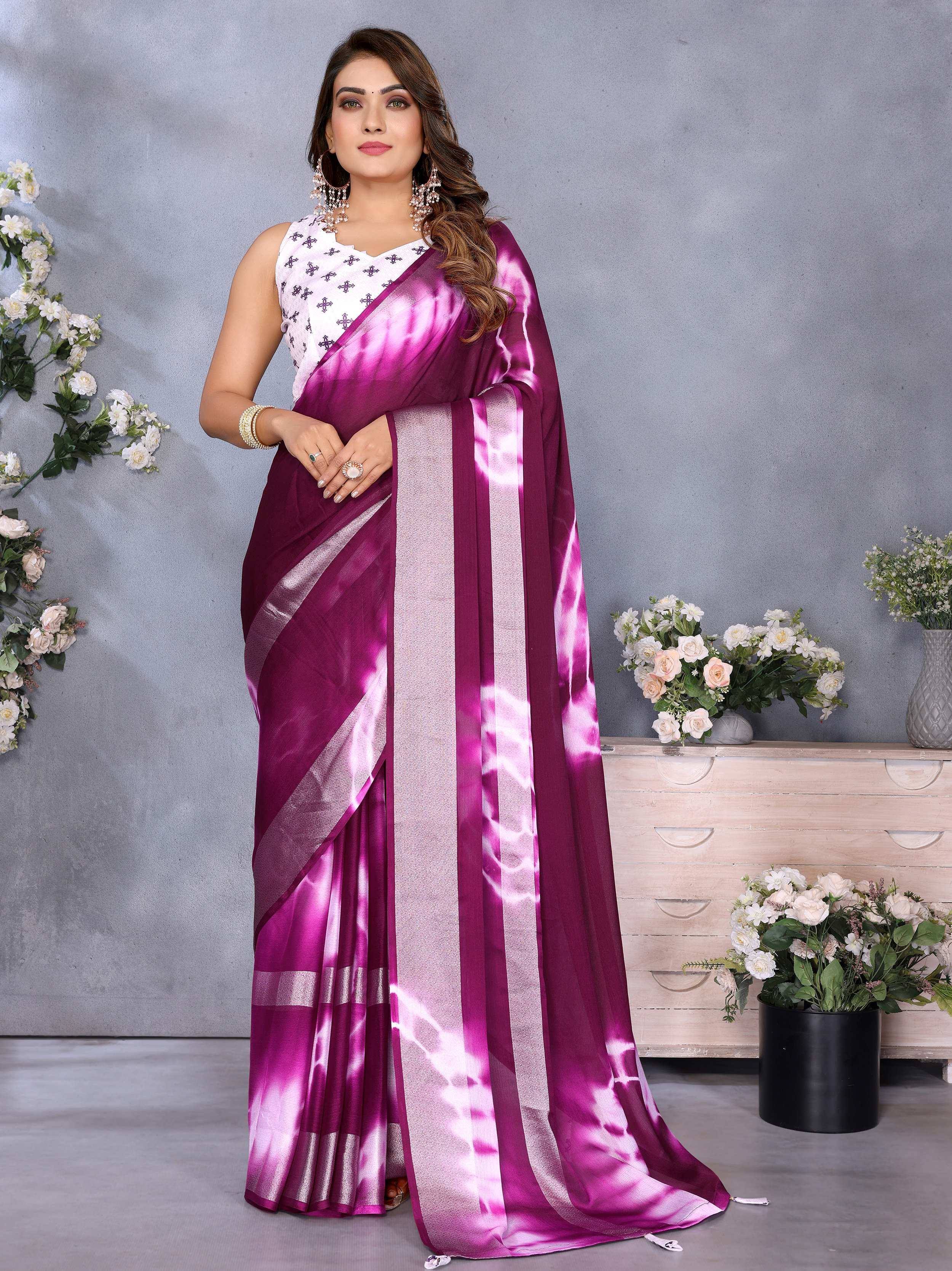 Woman in purple tie-dye saree with silver border and white embroidered blouse, styled for ethnic occasions.