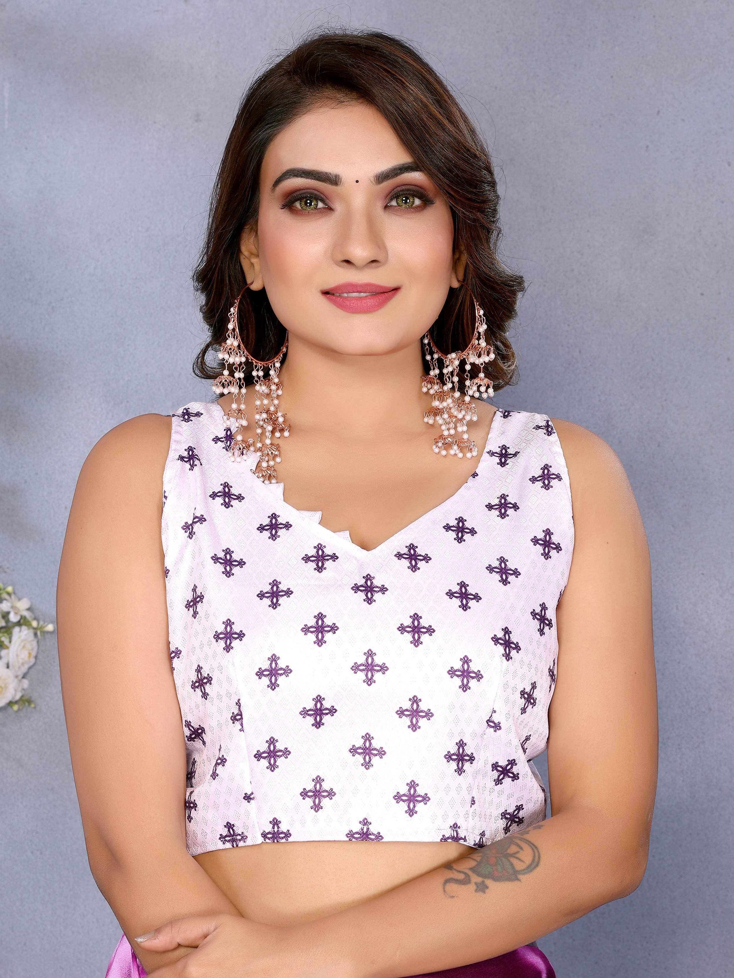 Woman in white and purple embroidered ethnic top with statement earrings