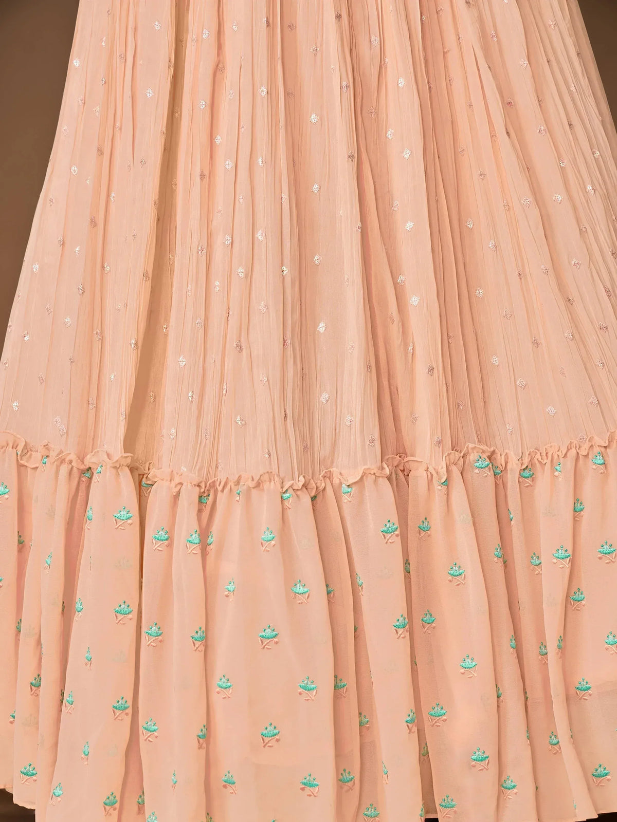 Peach ethnic gown with floral embroidery and ruffled hem, perfect for Indian occasions