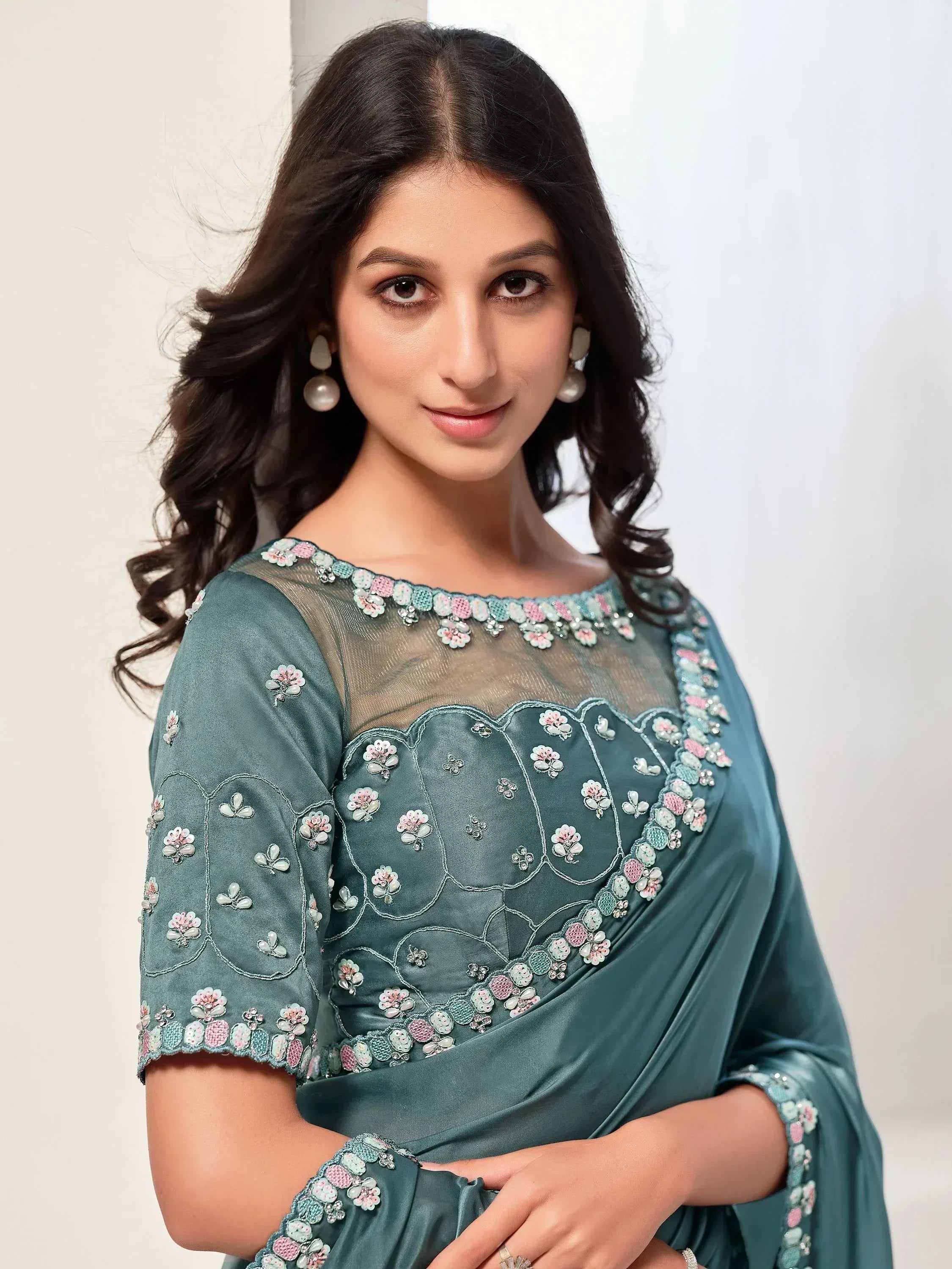 Teal saree with floral embroidery and sheer neckline, perfect for Indian ethnic wear occasions