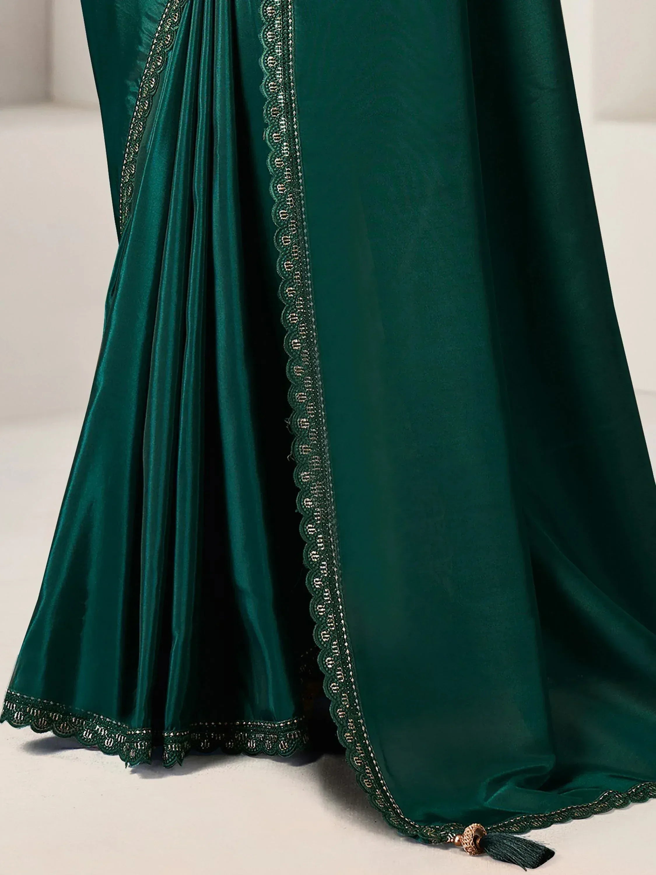 Emerald green velvet lehenga with scalloped lace trim and tassel detail, Indian ethnic wear