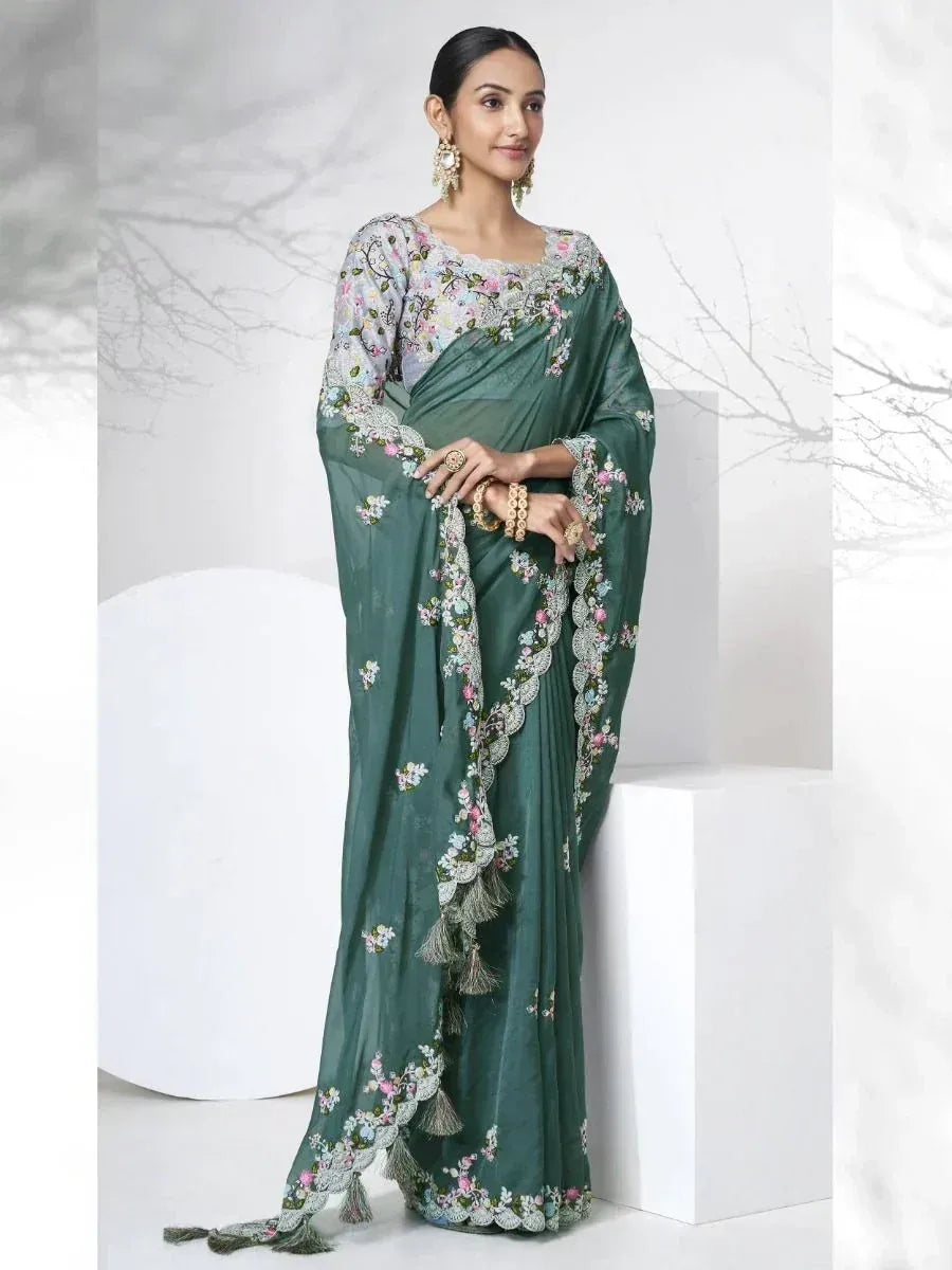 Emerald green floral embroidered saree with lace border and tassels, styled with matching blouse for Indian ethnic wear