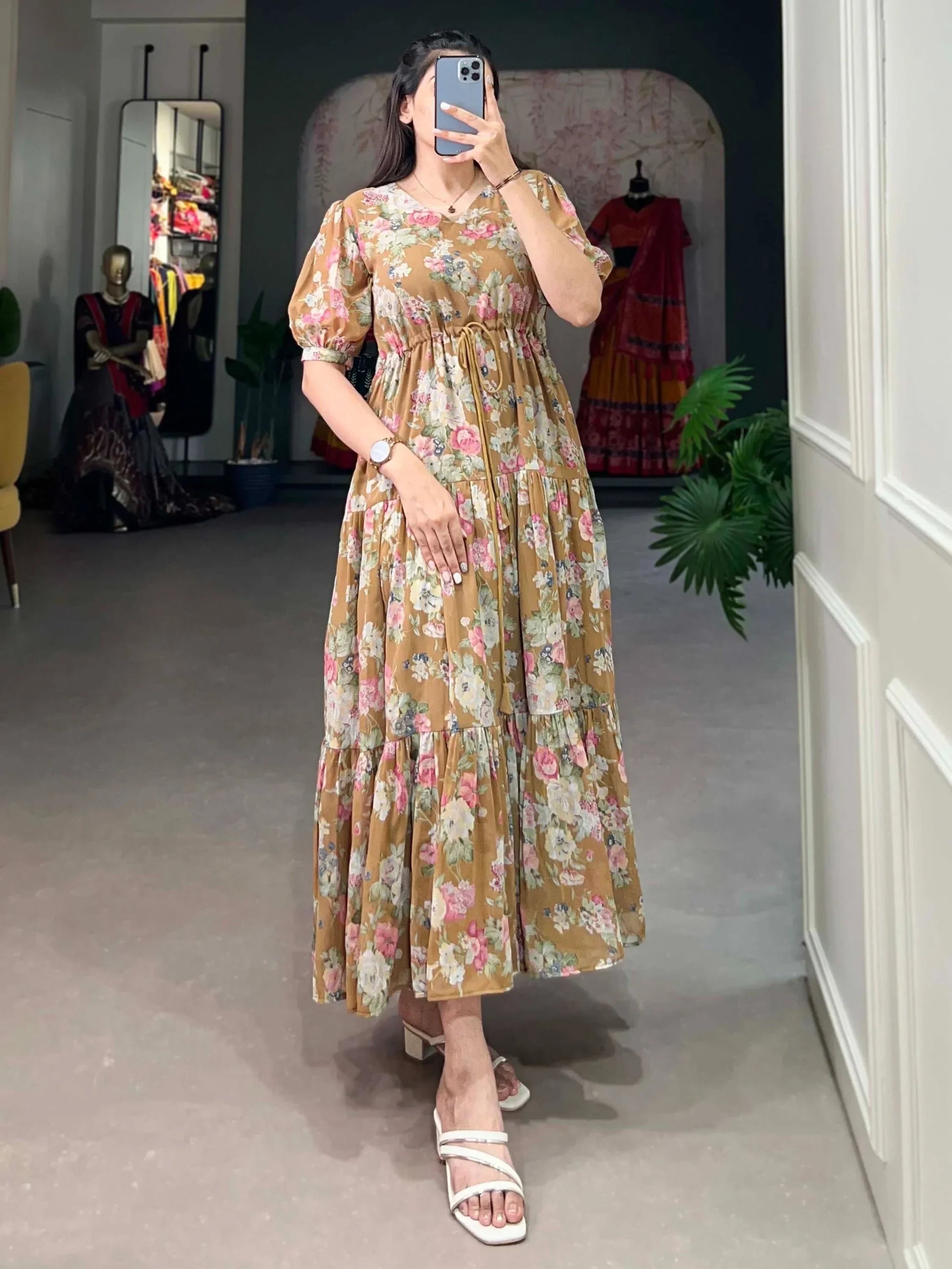 Woman wearing a brown floral maxi dress with puff sleeves in a boutique setting