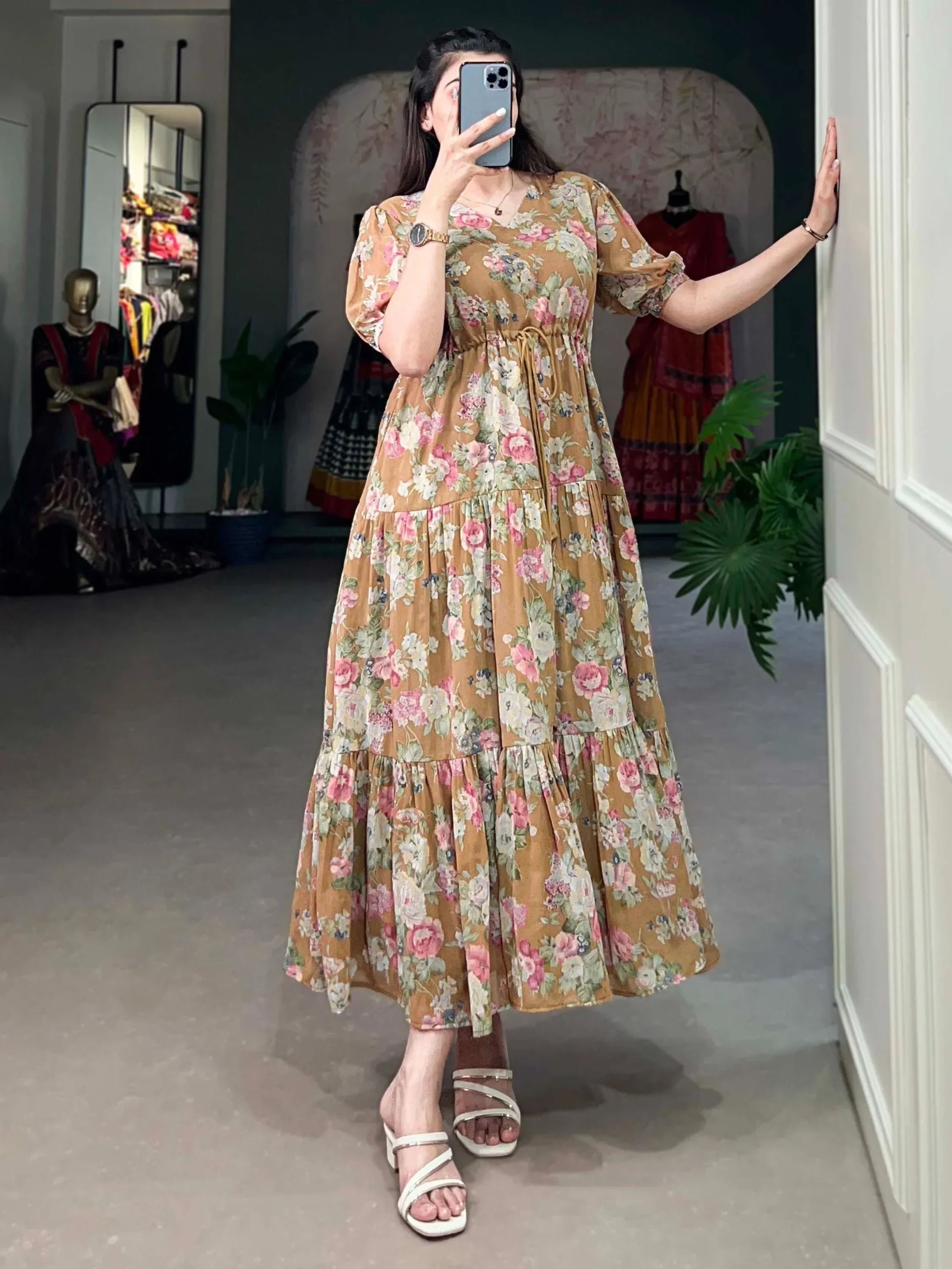 Woman wearing a brown floral print maxi dress with short sleeves and white sandals indoors