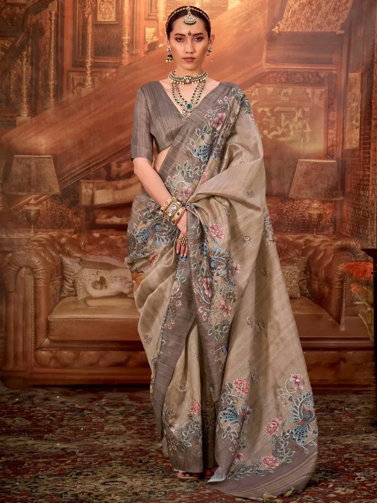 Elegant grey saree with floral and peacock embroidery, paired with traditional Indian jewelry for festive occasions.
