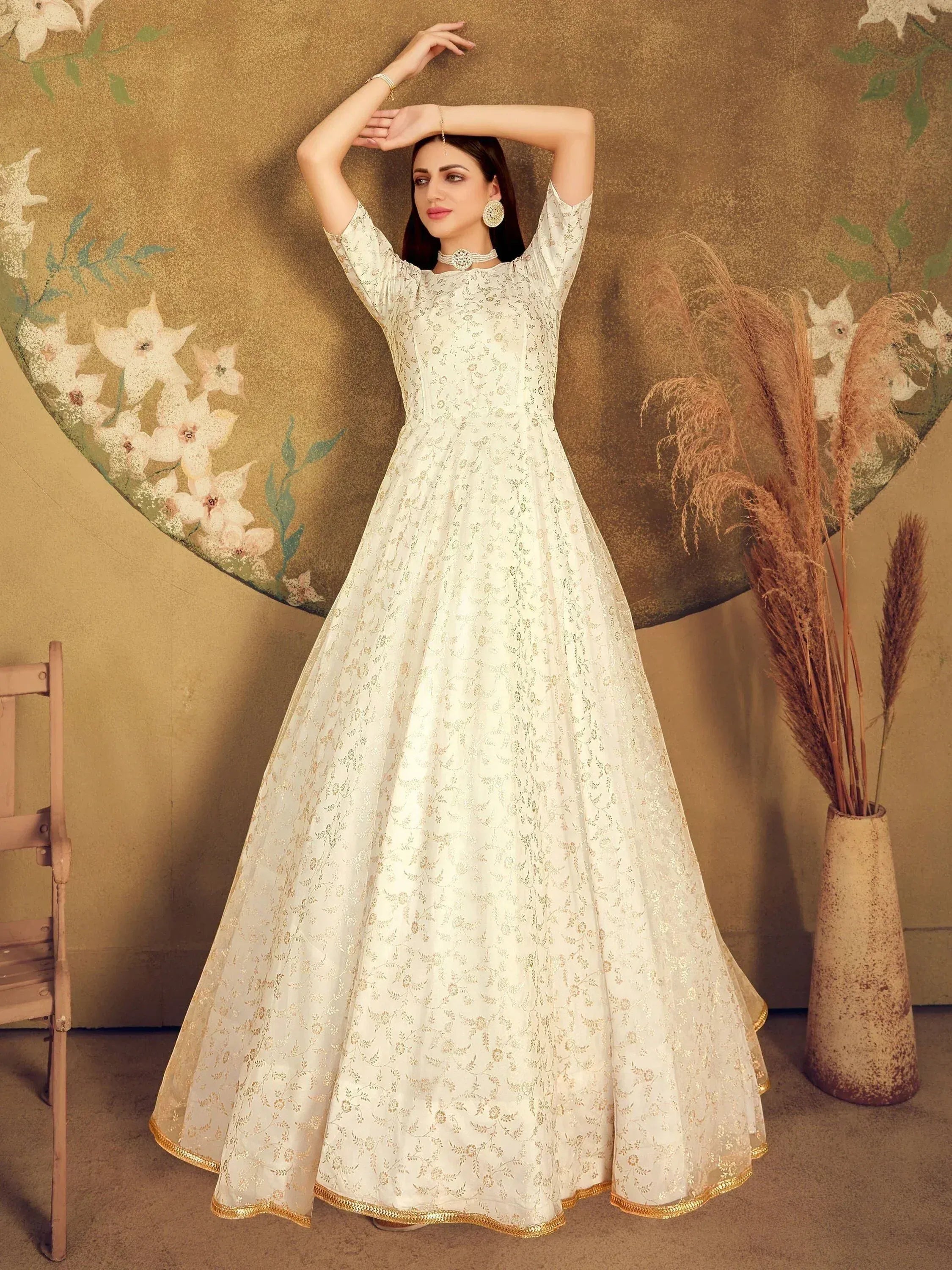 Elegant white ethnic gown with gold floral embroidery, perfect for Indian weddings and festive occasions.