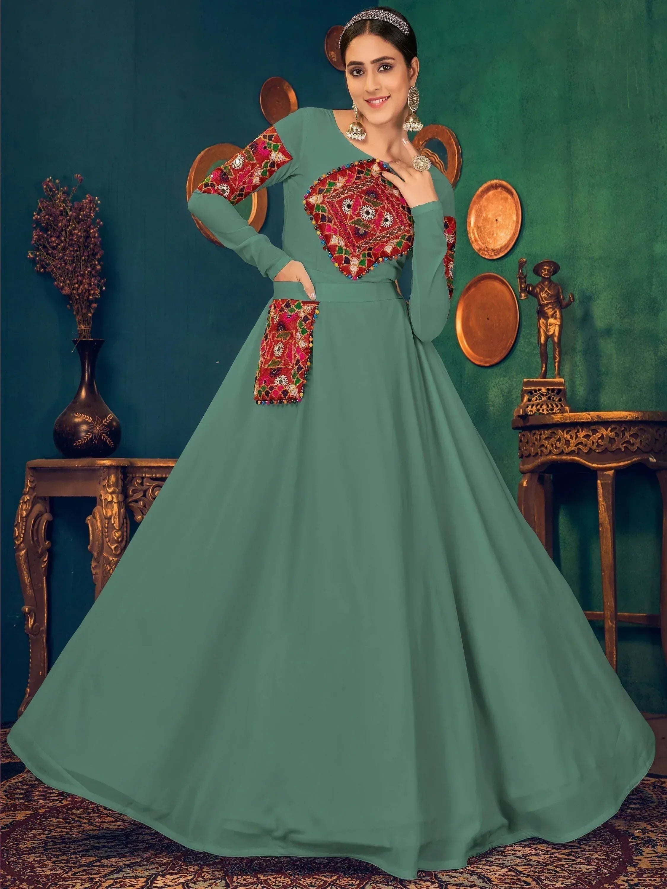 Teal ethnic gown with vibrant embroidered panels, perfect for Indian festive occasions and weddings.