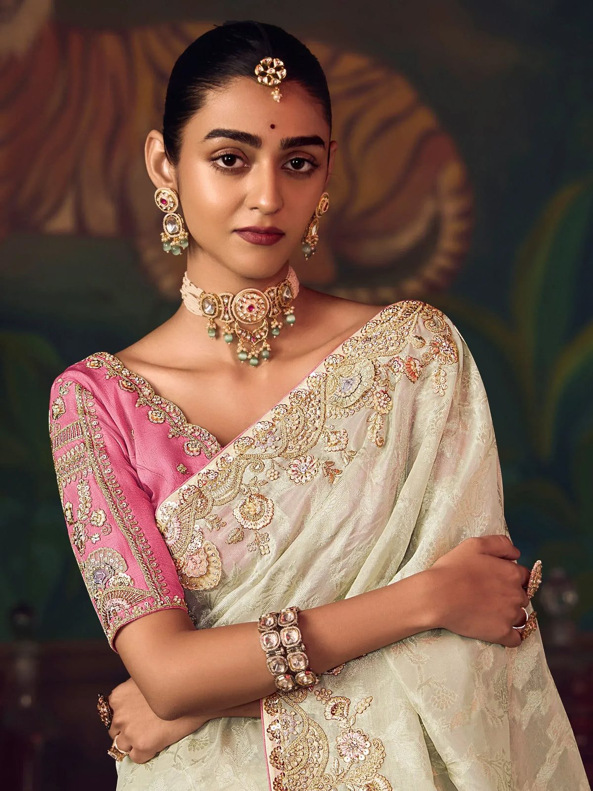 Elegant woman in embroidered saree with gold jewelry, showcasing Indian ethnic wear