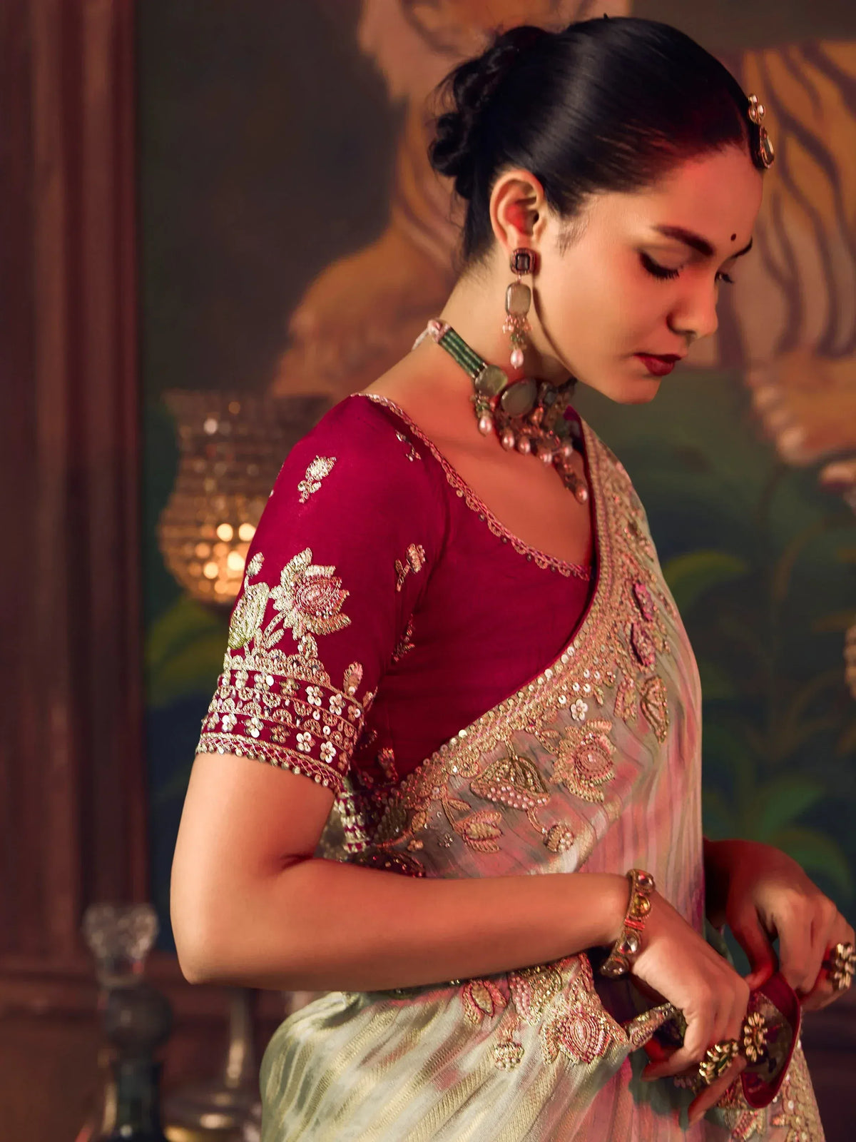 Elegant woman in maroon and gold embroidered saree with traditional jewelry