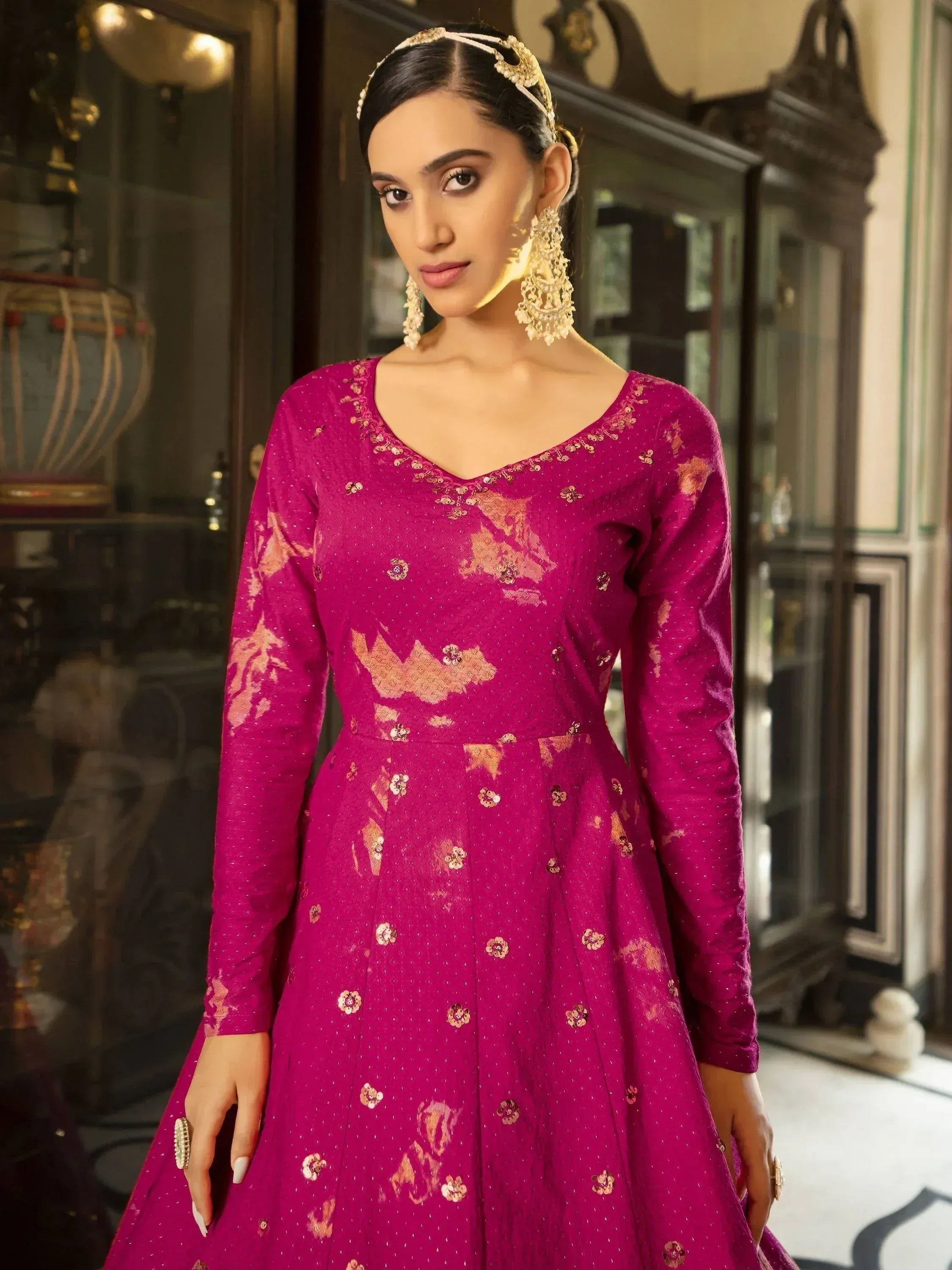 Fuchsia ethnic gown with gold floral embroidery, perfect for Indian weddings or festive occasions