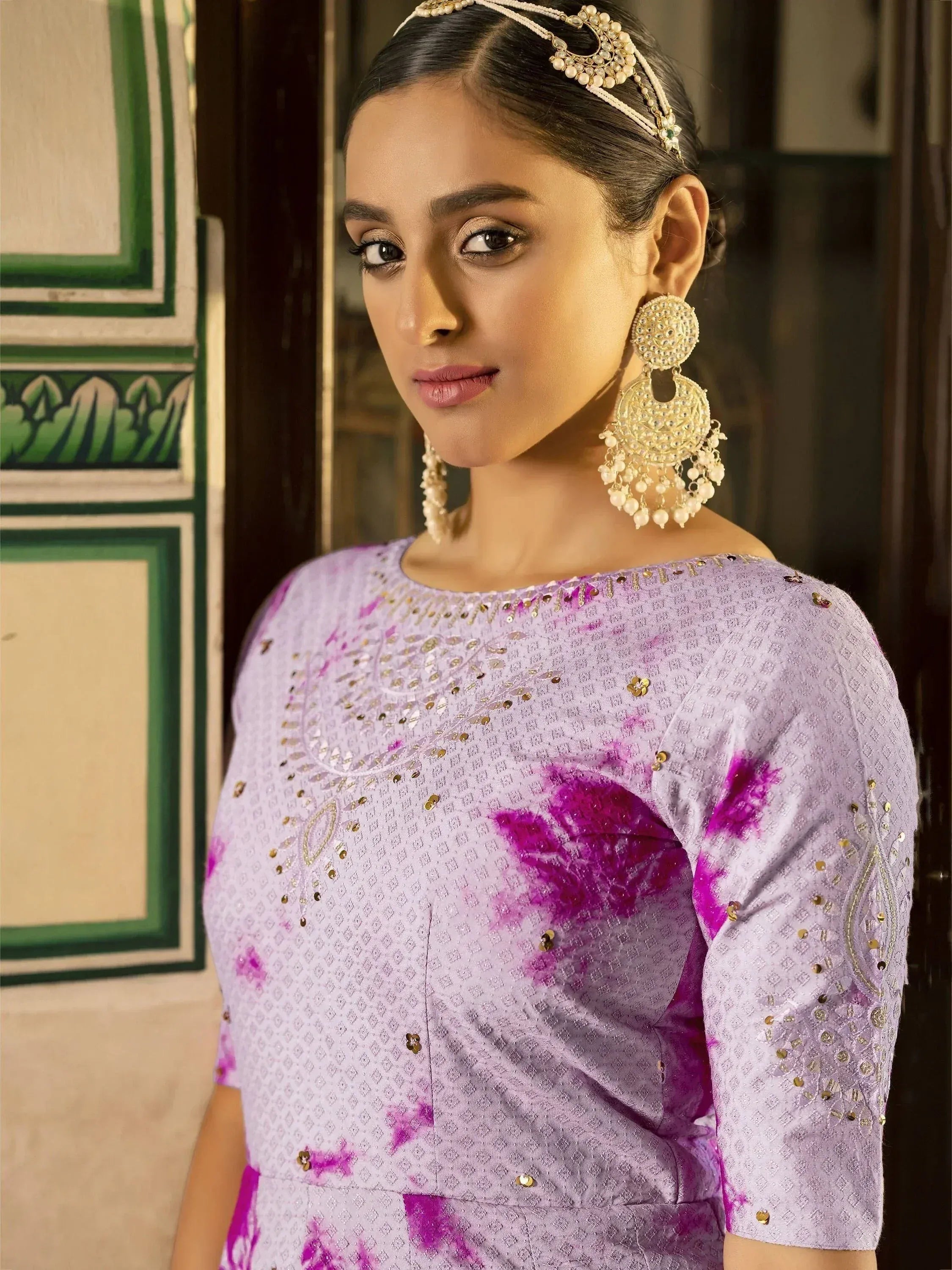 Purple tie-dye ethnic gown with gold embroidery and traditional jewelry for Indian wear