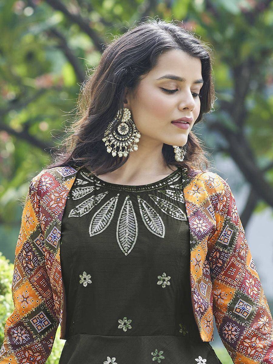 Woman in embroidered ethnic gown with colorful patchwork sleeves and statement earrings