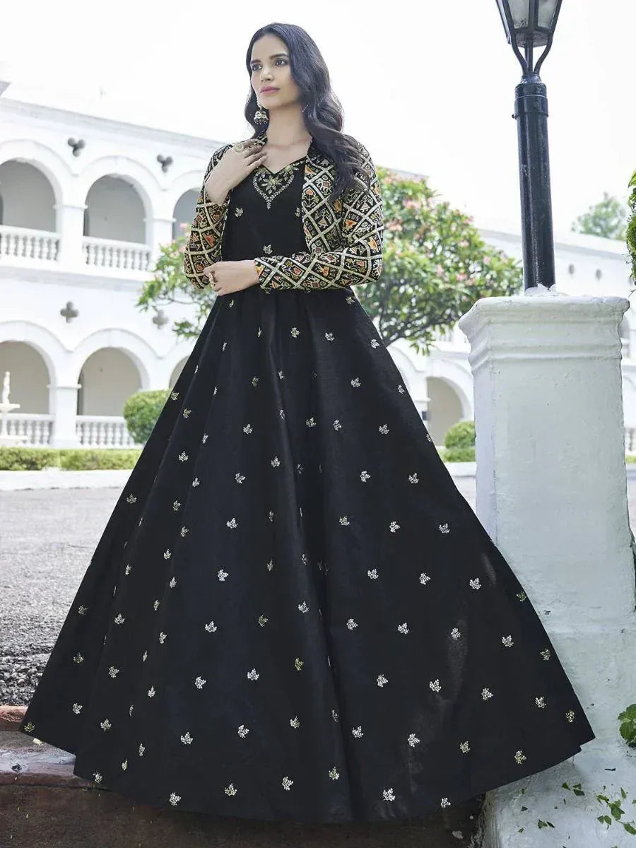 Woman in black embroidered ethnic gown with patterned sleeves, posing outdoors