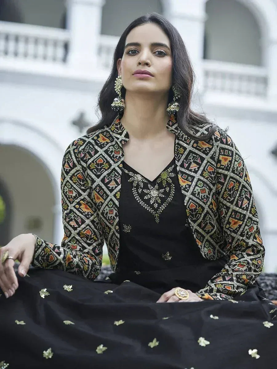 Woman in black embroidered ethnic gown with jacket, gold jewelry, and traditional earrings