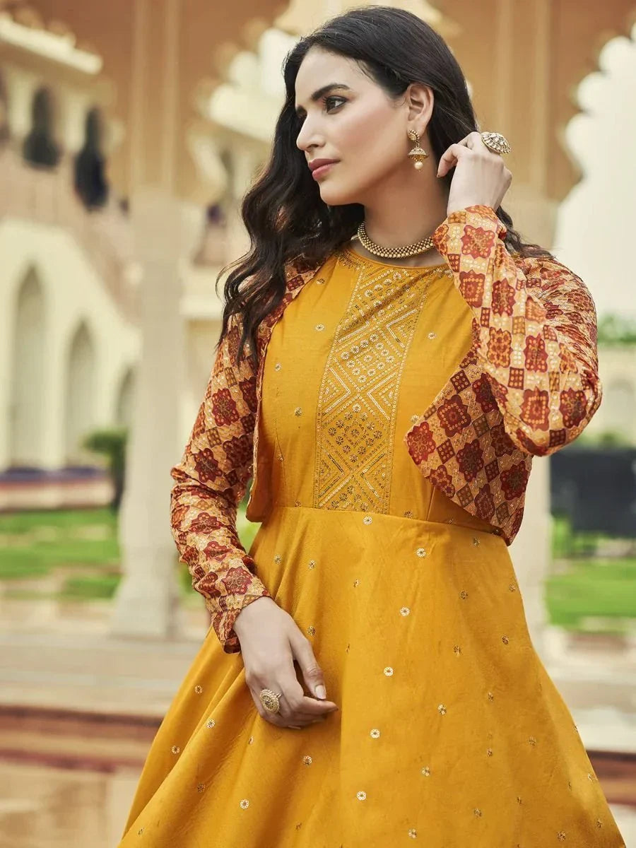Woman in mustard yellow embroidered Anarkali suit with printed red sleeves, ethnic jewelry