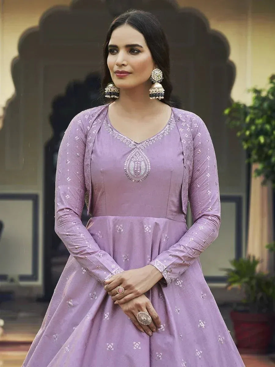 Lavender ethnic gown with intricate embroidery and traditional jhumka earrings, perfect for Indian festive occasions