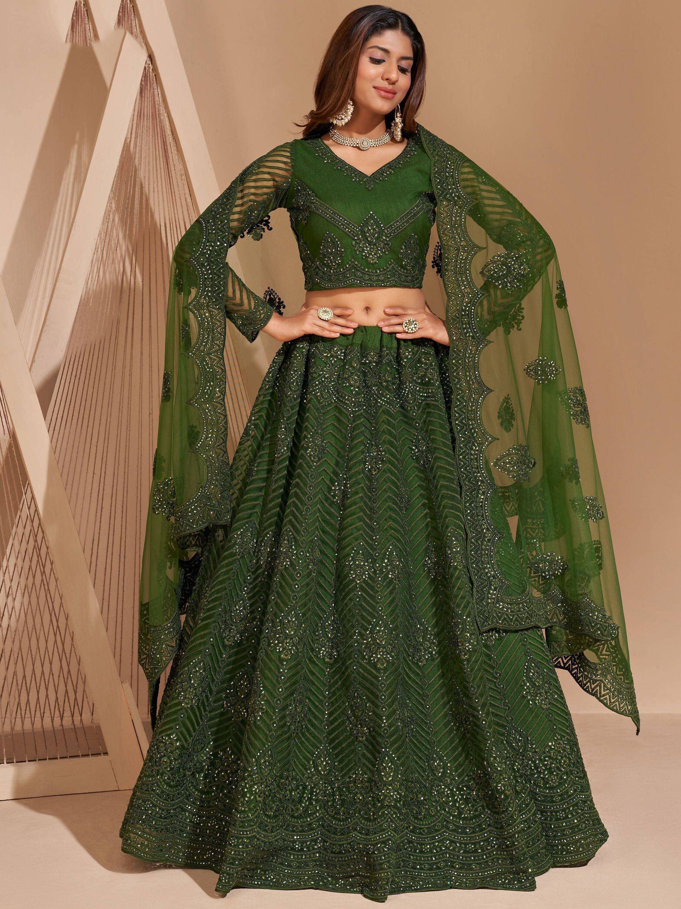 Emerald green designer lehenga choli with heavy embroidery and sheer cape, perfect for Indian weddings.