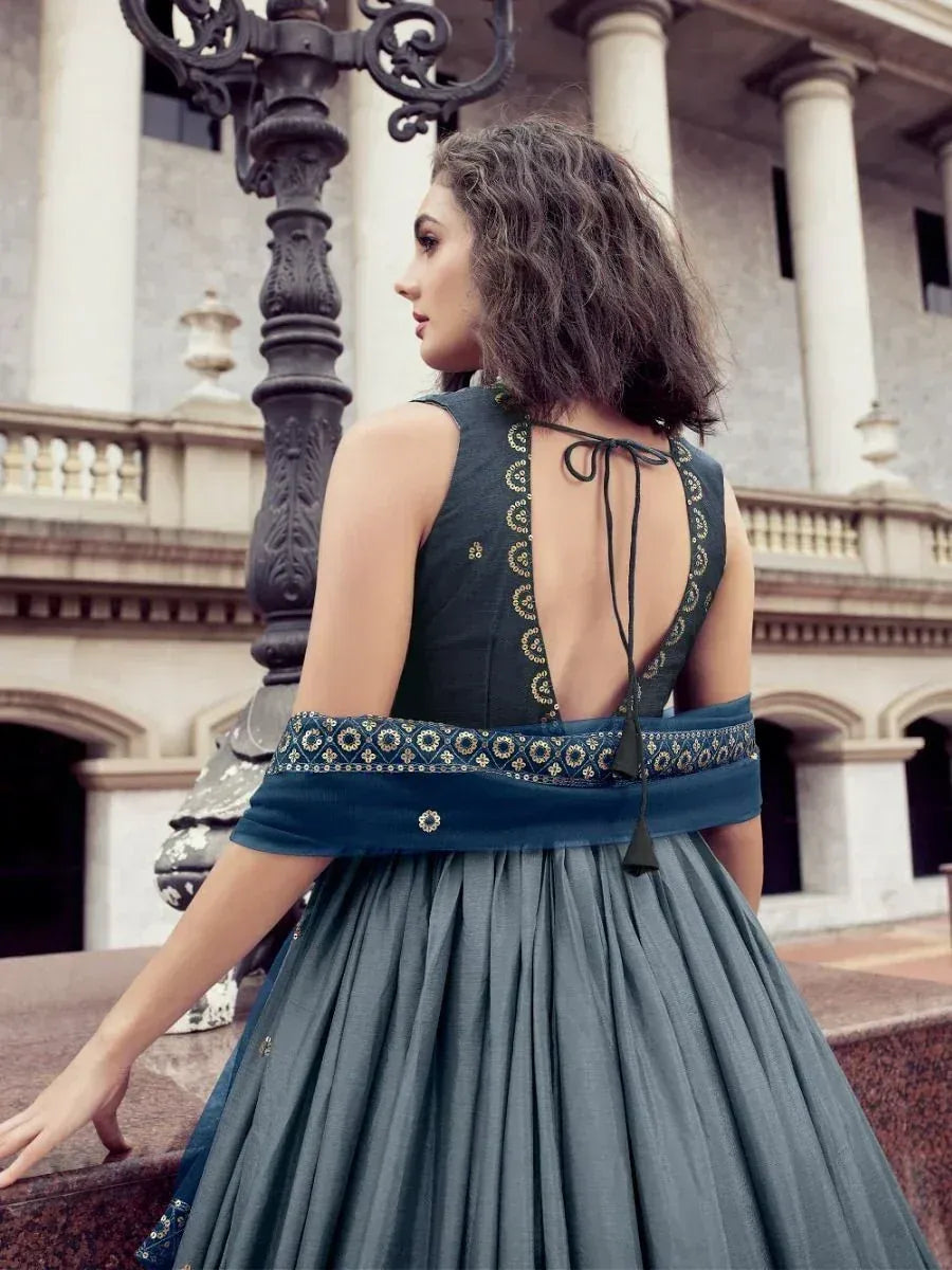 Elegant teal ethnic gown with open back and gold embroidery, perfect for Indian festive occasions.
